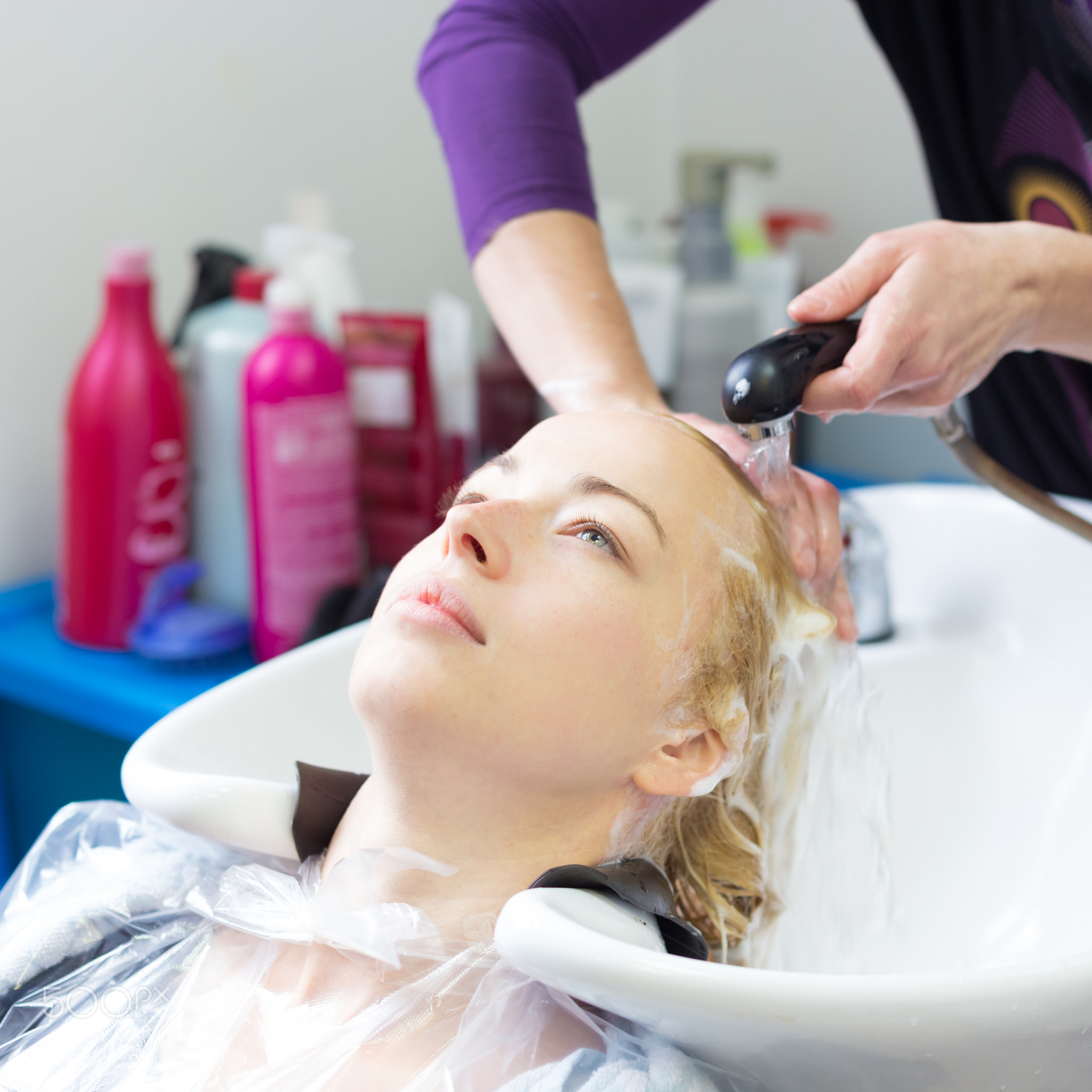 Hairdresser salon. Woman during hair wash.