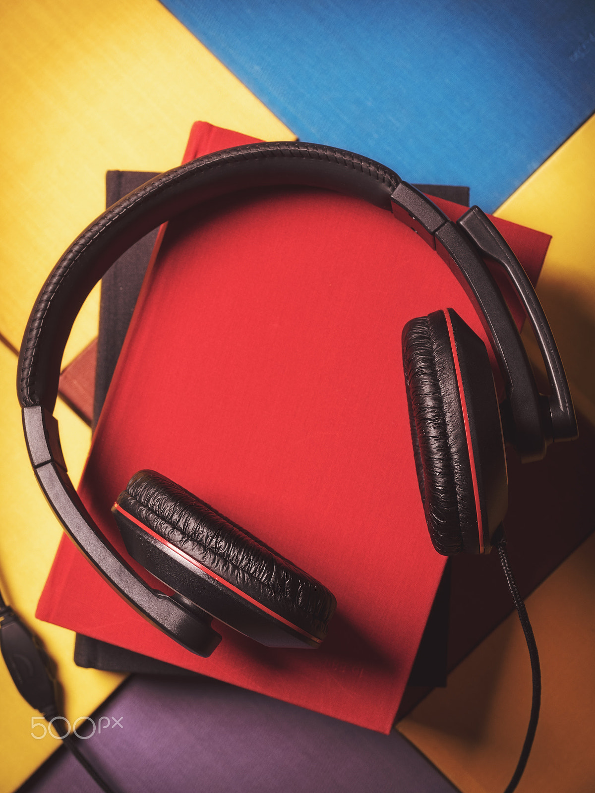 Olympus OM-D E-M1 + OLYMPUS 14-54mm Lens sample photo. Pile of books with headphones photography
