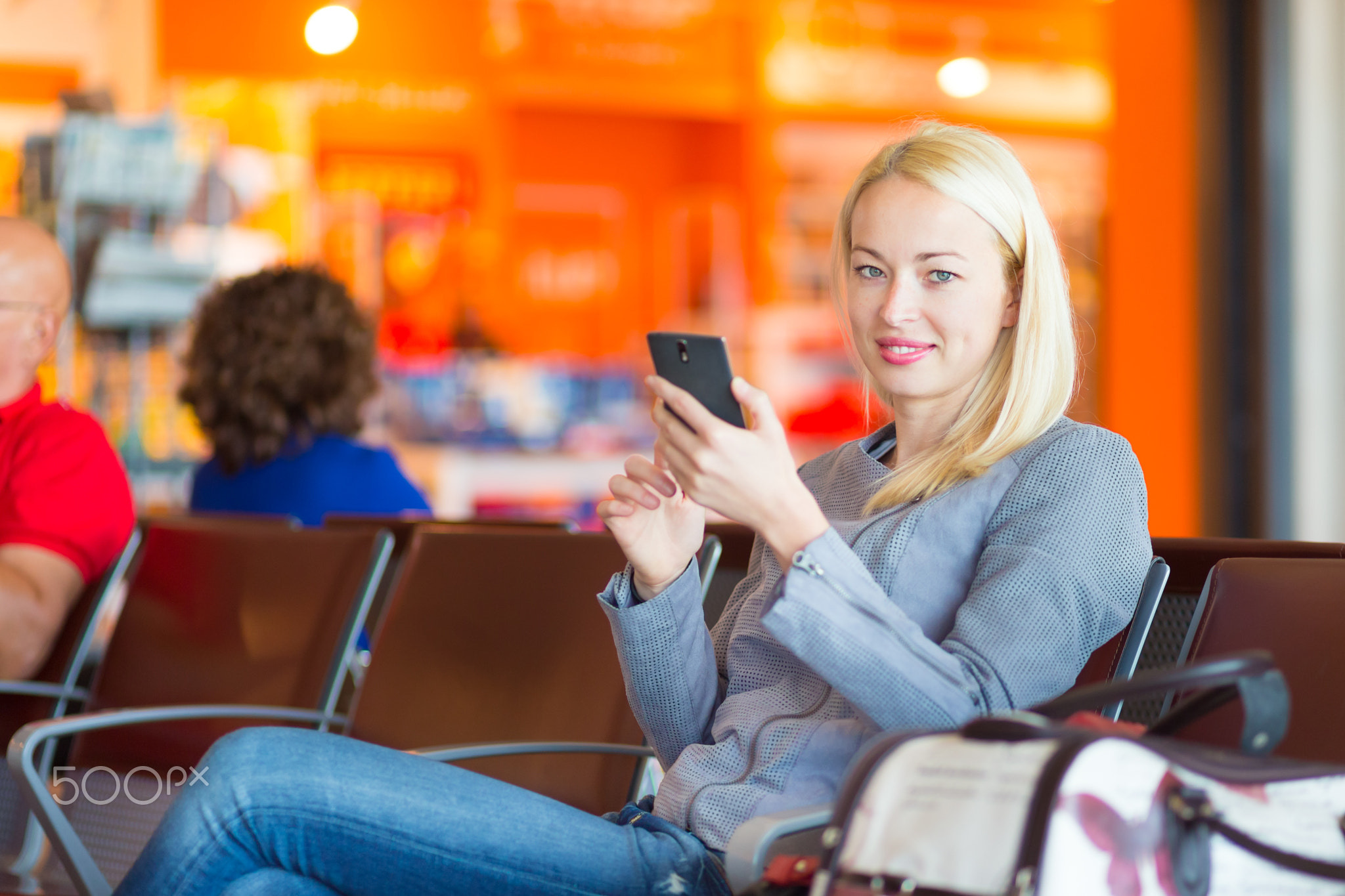 Female traveler using cell phone while waiting.
