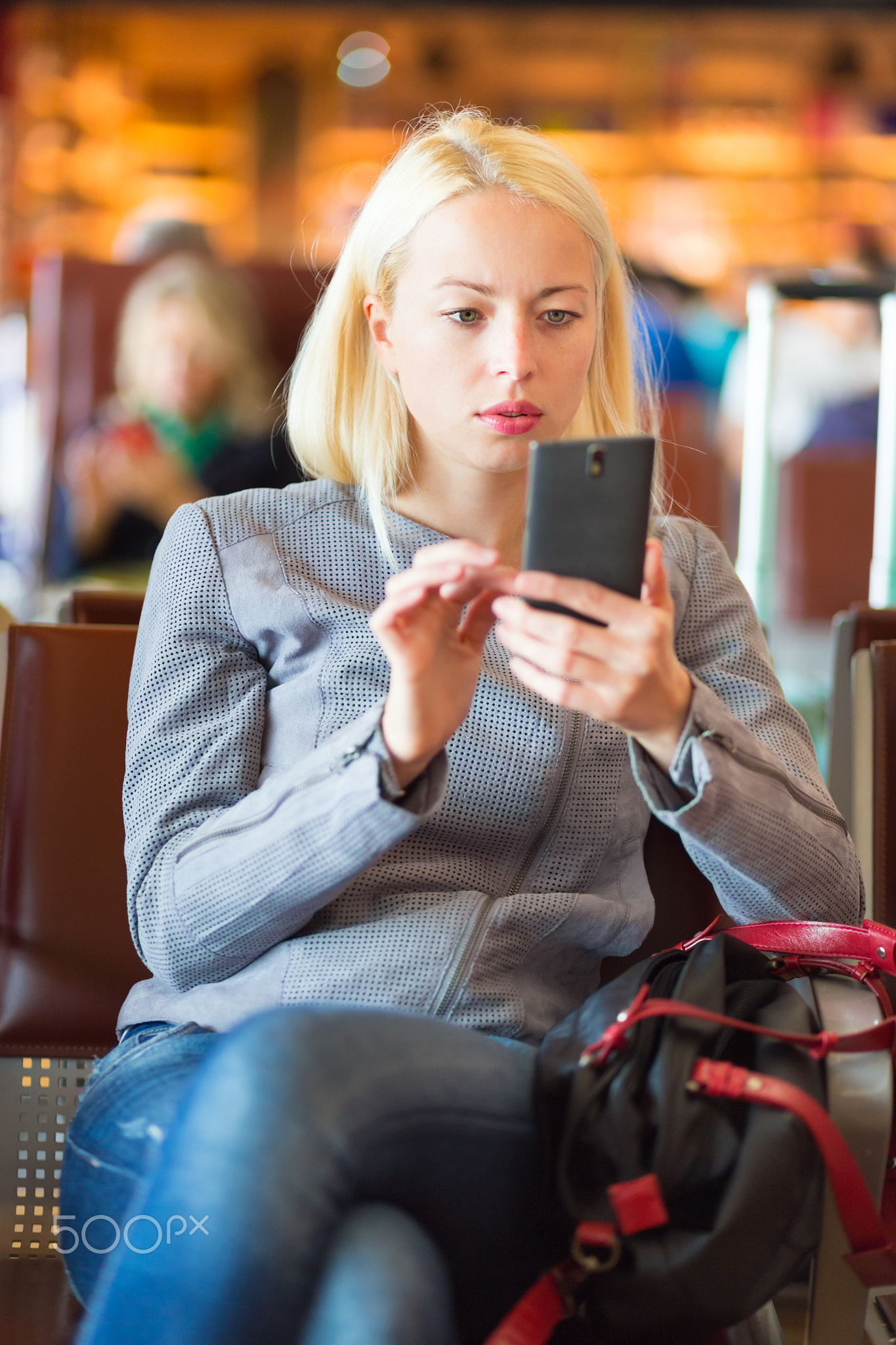 Female traveler using cell phone while waiting.