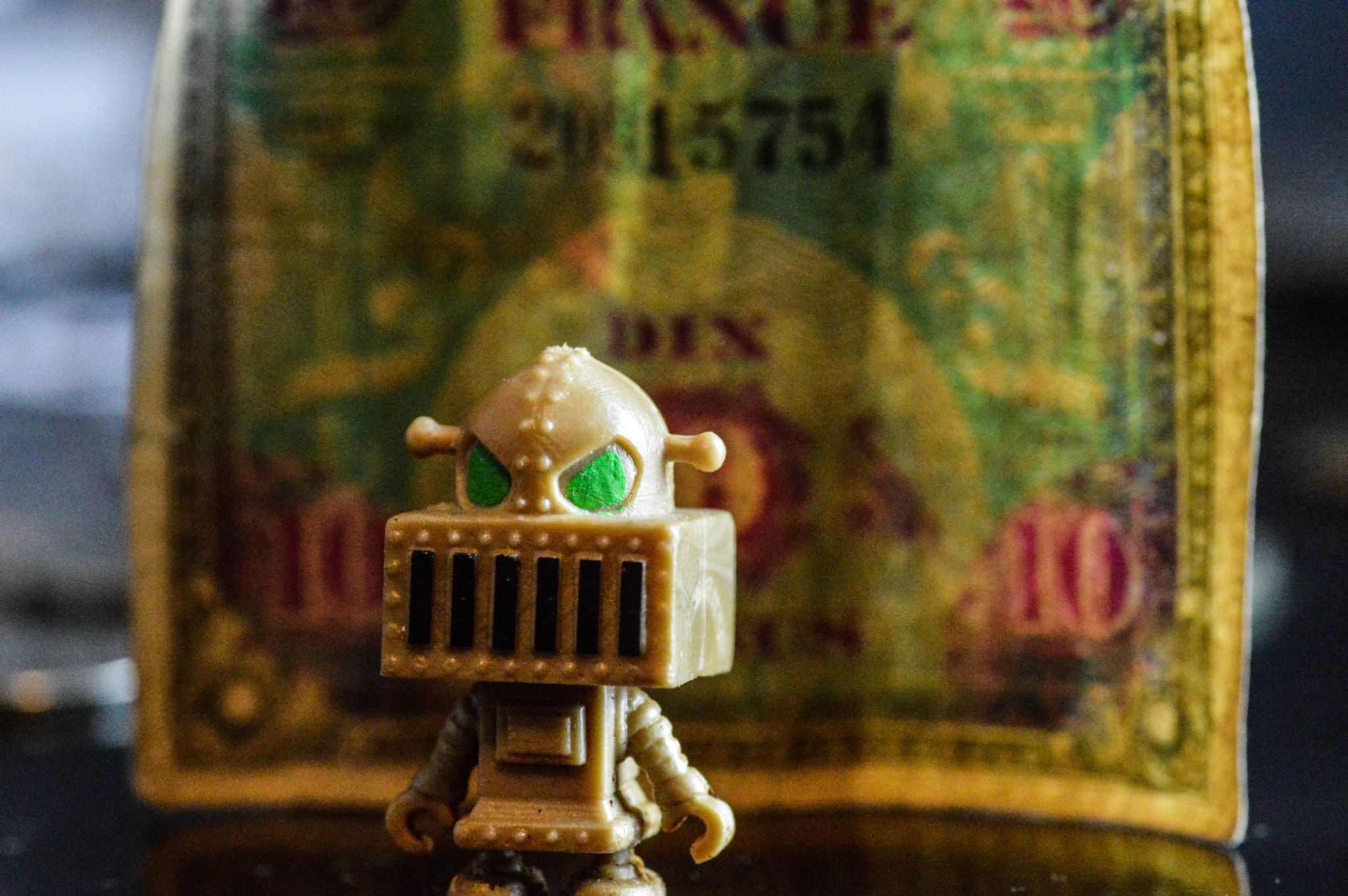 Nikon D3200 + Tamron SP 90mm F2.8 Di VC USD 1:1 Macro sample photo. Close up of vending machine robot with d day landing currency as a backdrop. photography