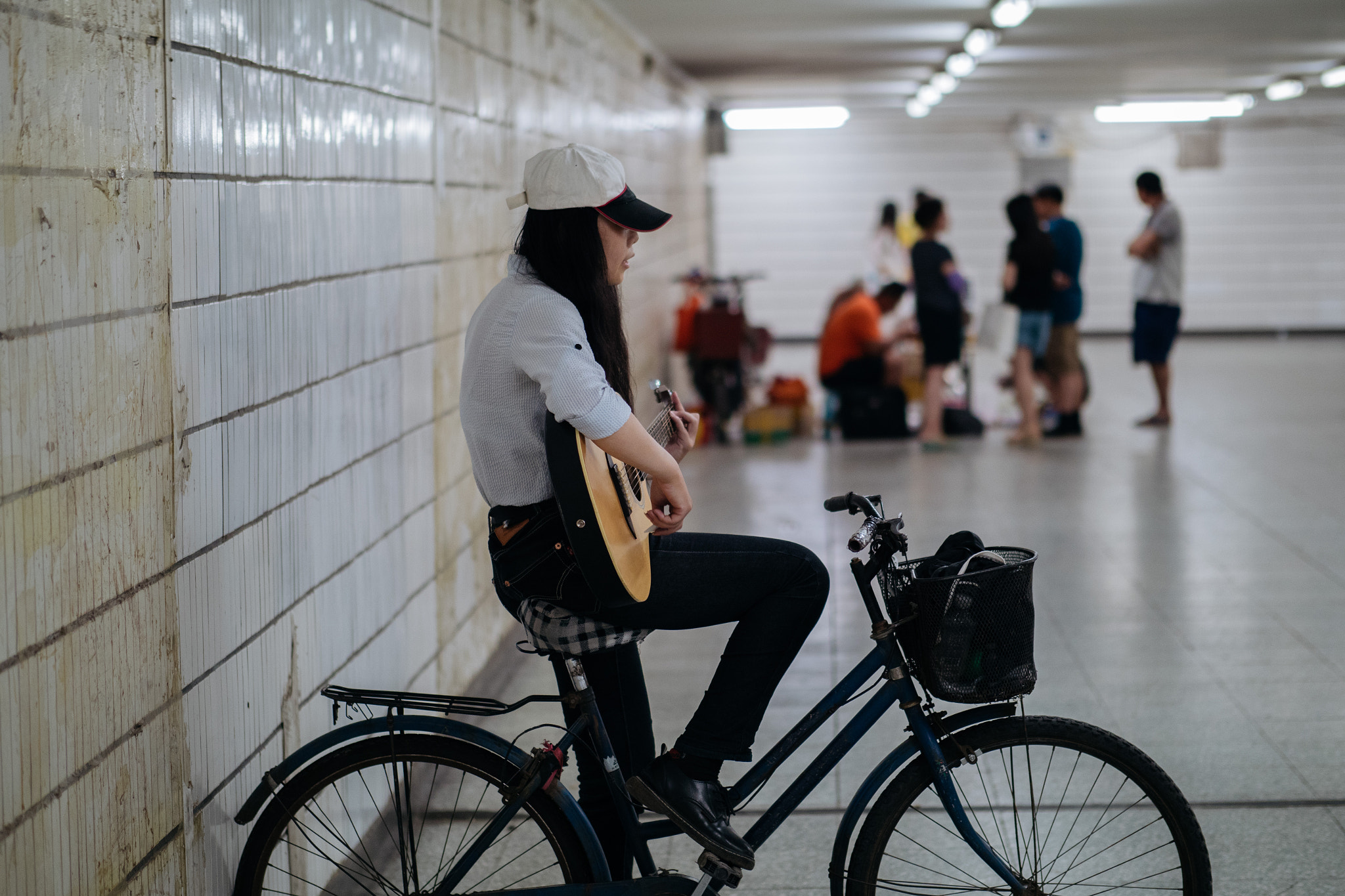 Panasonic Lumix DMC-GX8 + Panasonic Leica DG Nocticron 42.5mm F1.2 ASPH OIS sample photo. A busker girl in the underpass photography