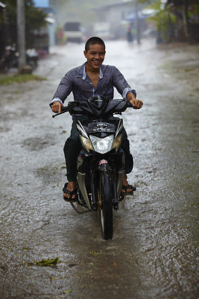young man riding motorcycle in the rain