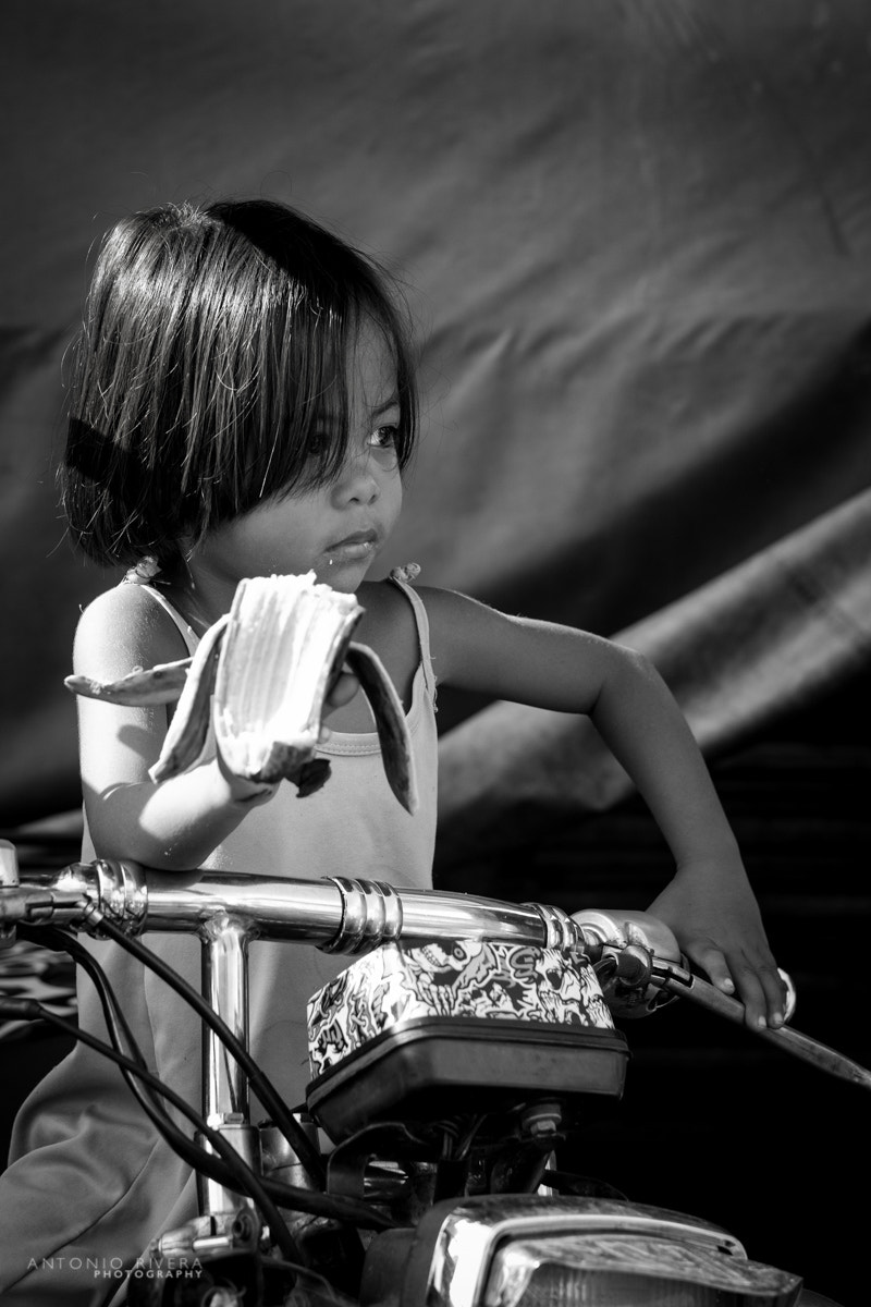 Fujifilm X-Pro1 + Fujifilm XF 56mm F1.2 R APD sample photo. Biker child eating a banana photography