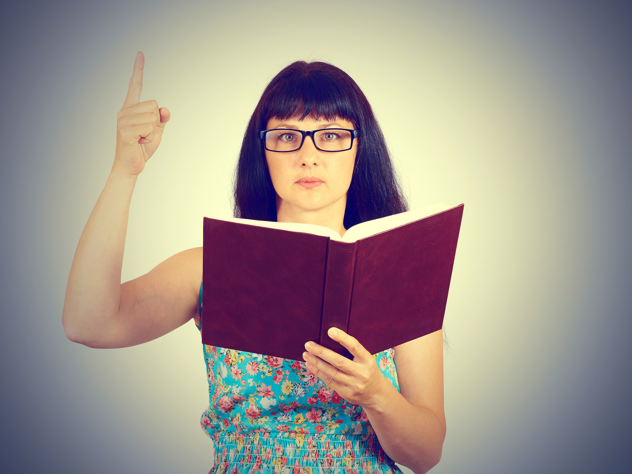 The teacher with glasses holding a book in his hands. Showing th