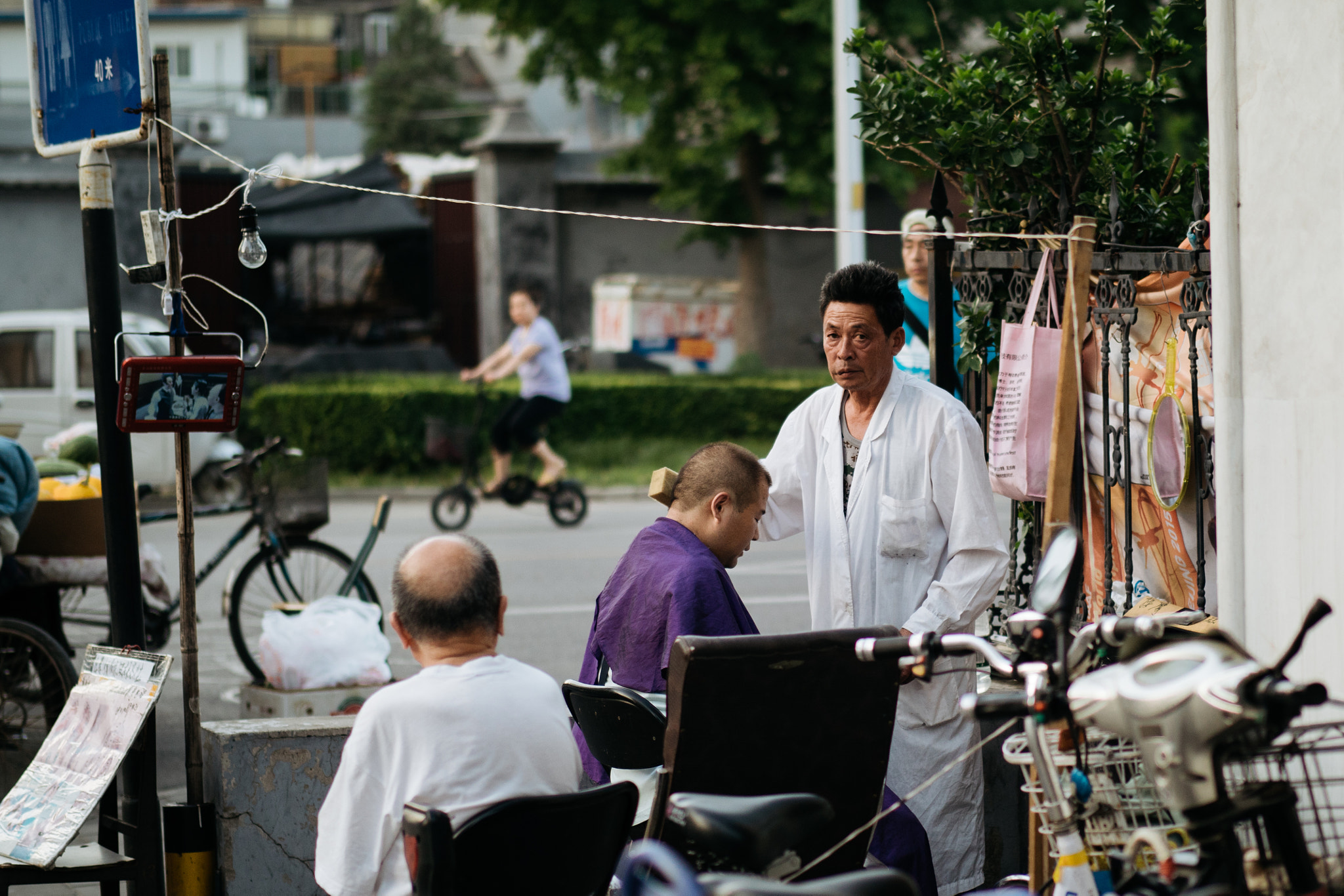 Panasonic Leica DG Nocticron 42.5mm F1.2 ASPH OIS sample photo. Barber and his customer photography