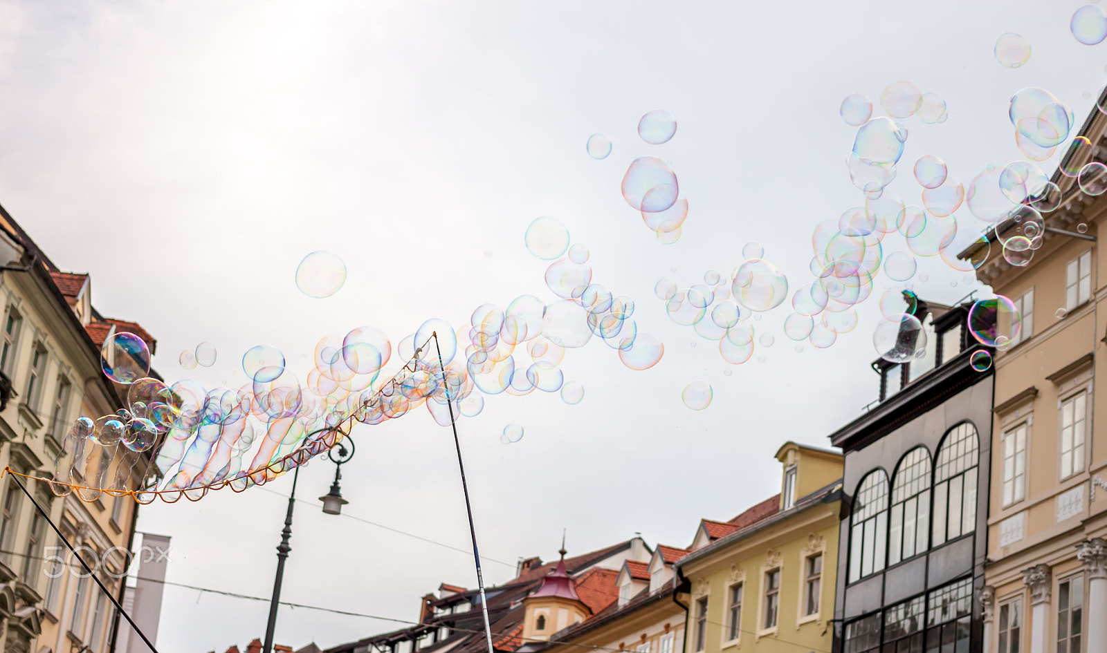 Canon EOS 500D (EOS Rebel T1i / EOS Kiss X3) + Canon EF 40mm F2.8 STM sample photo. Soap bubbles on background of old town photography