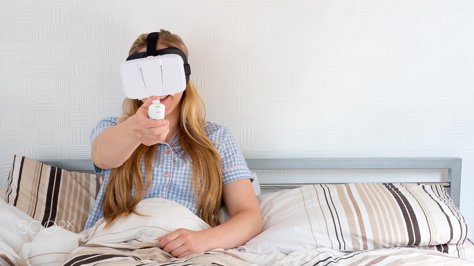 Panasonic Lumix DMC-GH4 + Panasonic Leica DG Summilux 25mm F1.4 II ASPH sample photo. Beautiful woman using vr headset in bed photography