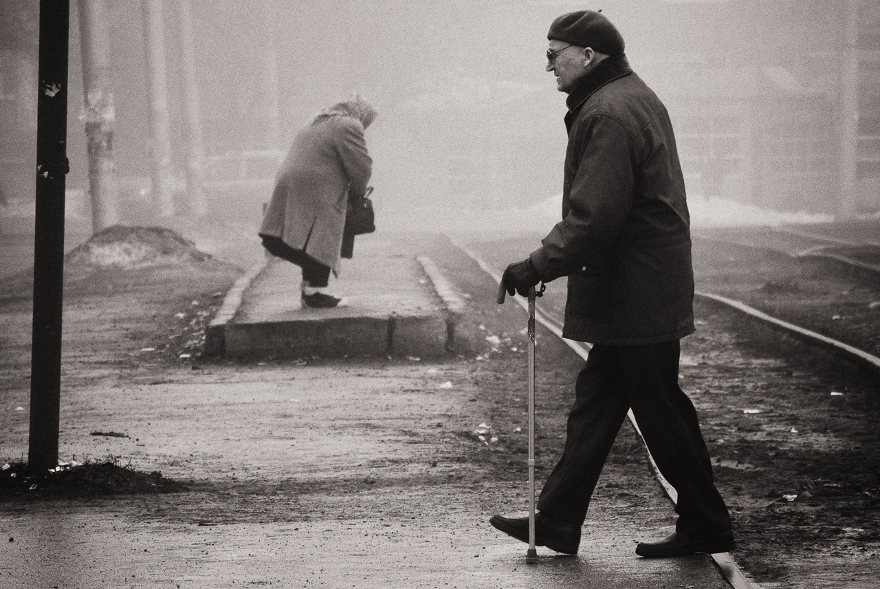 Nikon 1 Nikkor VR 30-110mm F3.8-5.6 sample photo. Two old people on the rainy street photography