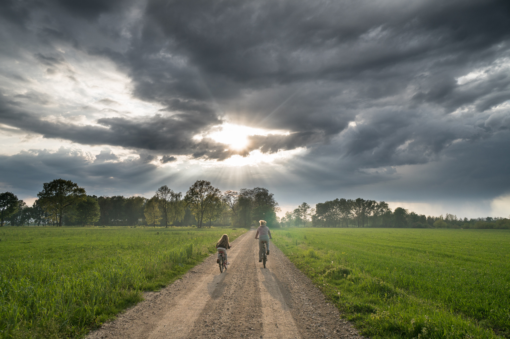 Sony a6300 + Sony E 16mm F2.8 sample photo. Cloudy sky over a road crossing a meadow photography