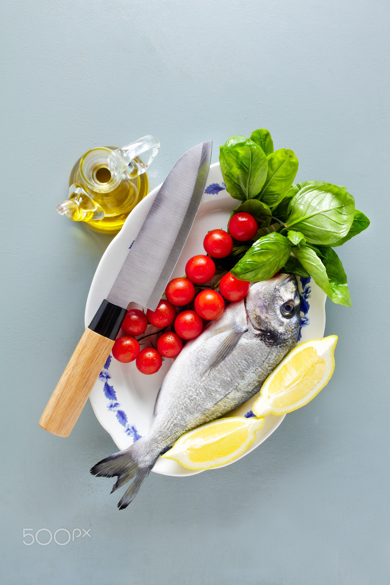 Fresh uncooked dorado or sea bream fish with lemon, herbs, oil,