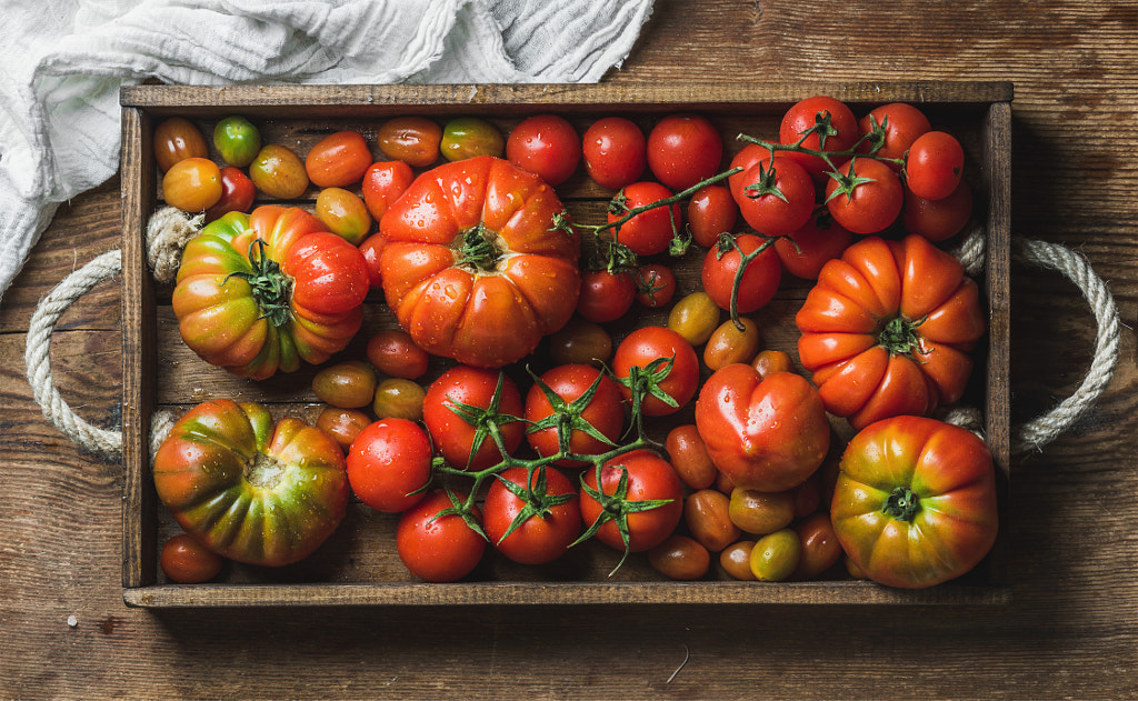 Colorful Heirloom tomatoes in rustic wooden tray over dark background by Anna Ivanova on 500px.com