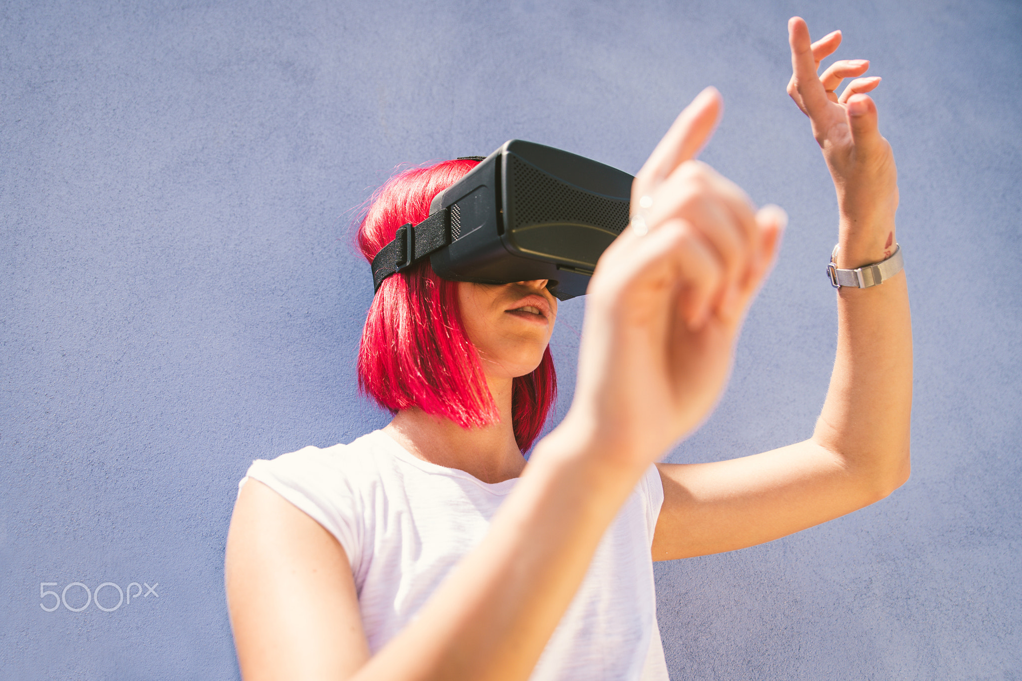 Young redhead woman playing with virtual reality visor