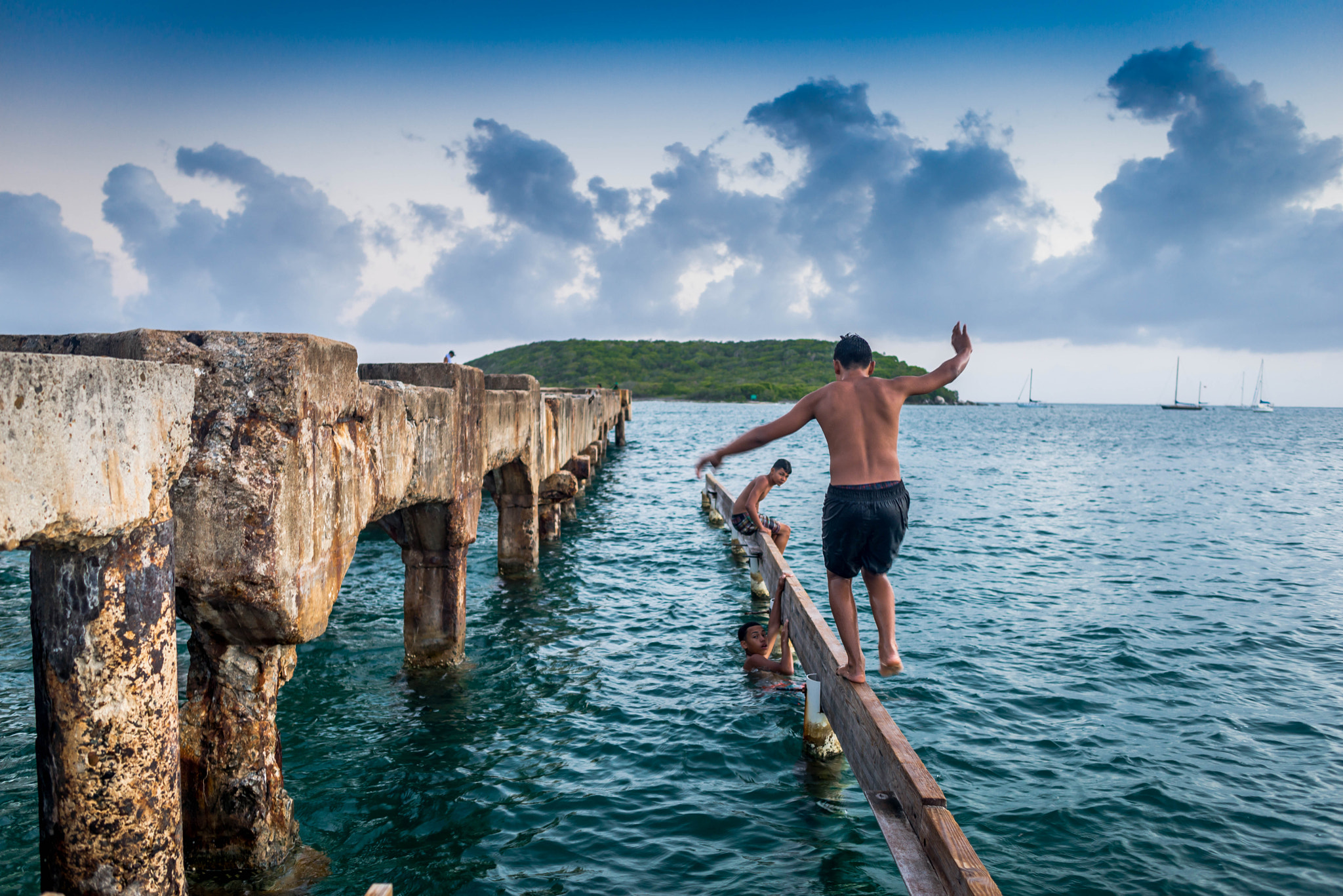 Nikon D600 + Nikon AF-S Nikkor 28mm F1.8G sample photo. Kids playing on an abandoned dock in vieques, puerto rico. photography