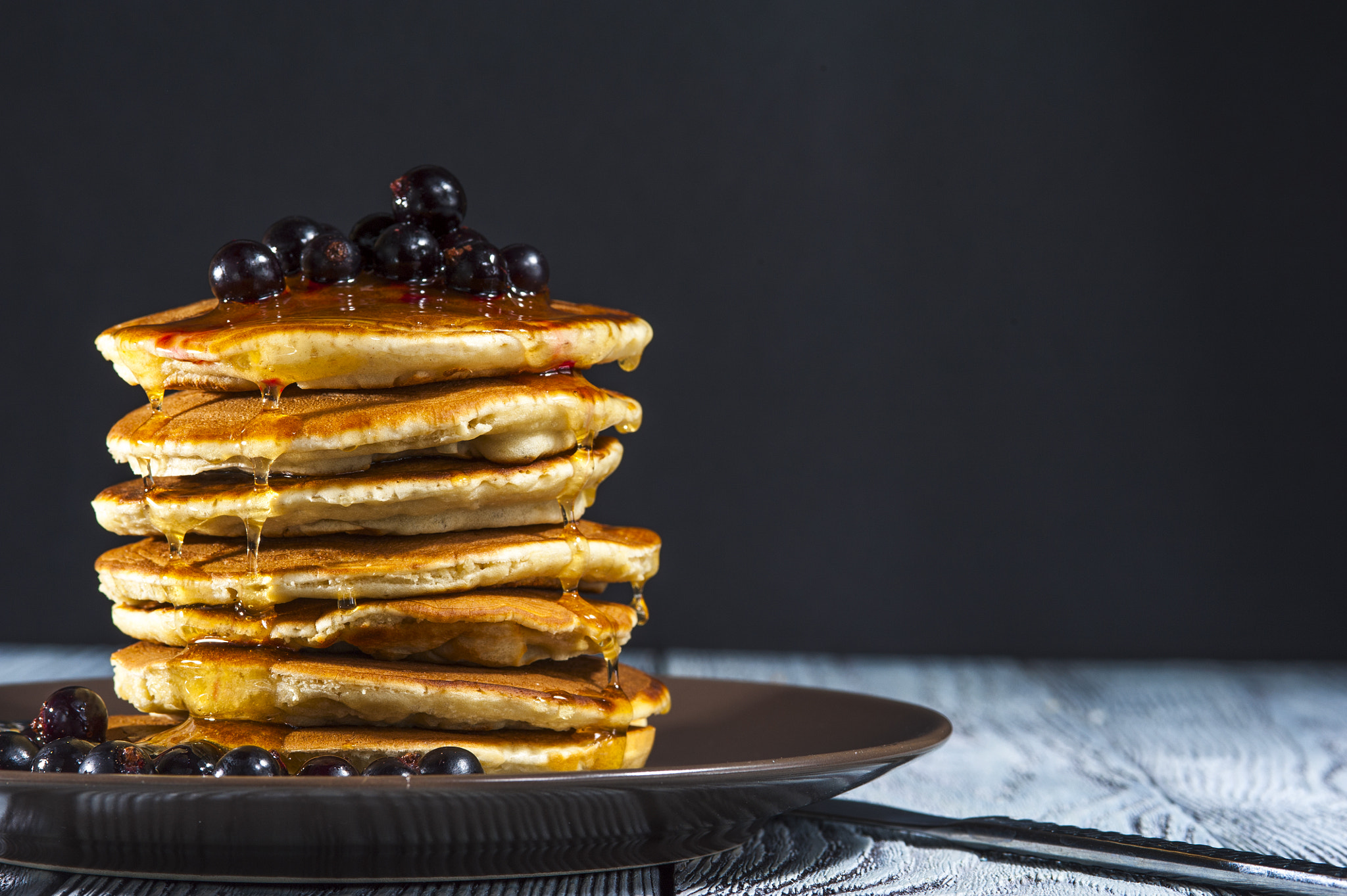 Nikon D700 + AF Micro-Nikkor 105mm f/2.8 sample photo. Stack of homemade pancakes with berries and honey on brown plate on rustic background. russian... photography