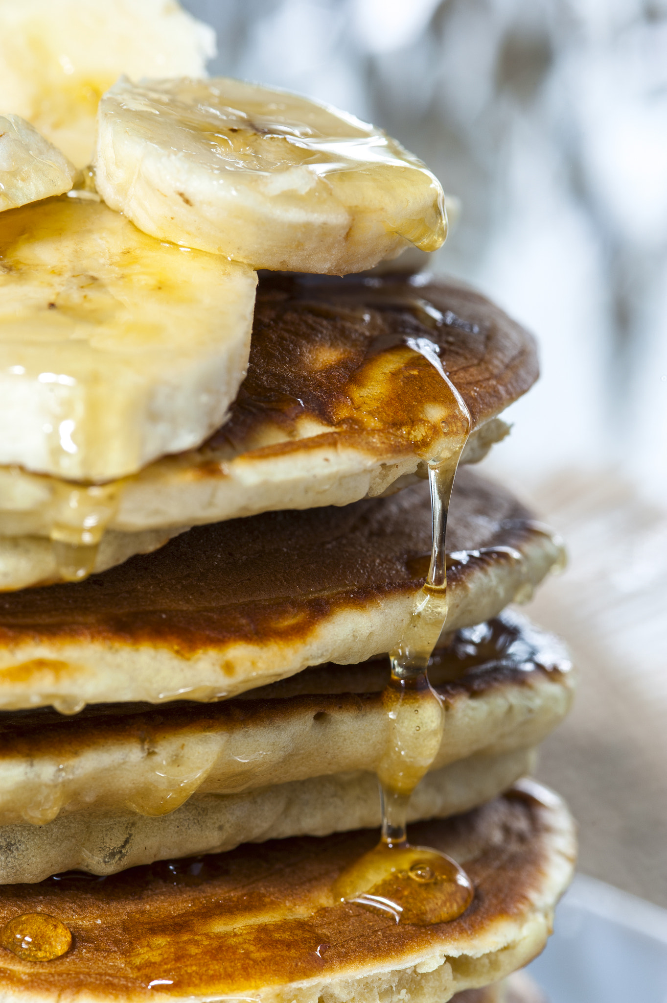 Nikon D700 + AF Micro-Nikkor 105mm f/2.8 sample photo. Stack of homemade pancakes with banana slices and honey, close up. russian holiday pancake... photography