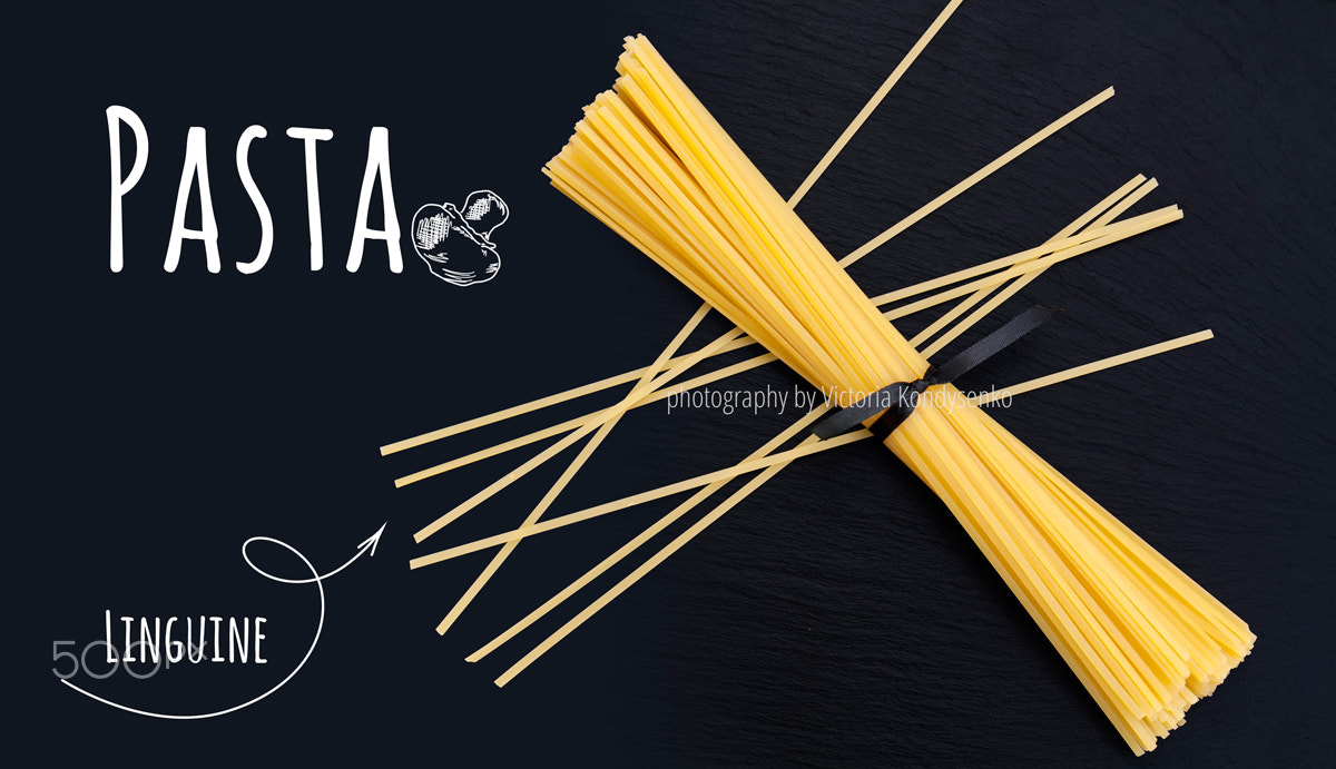 Canon EOS 1000D (EOS Digital Rebel XS / EOS Kiss F) sample photo. Uncooked italian pasta linguine on black slate stone background photography