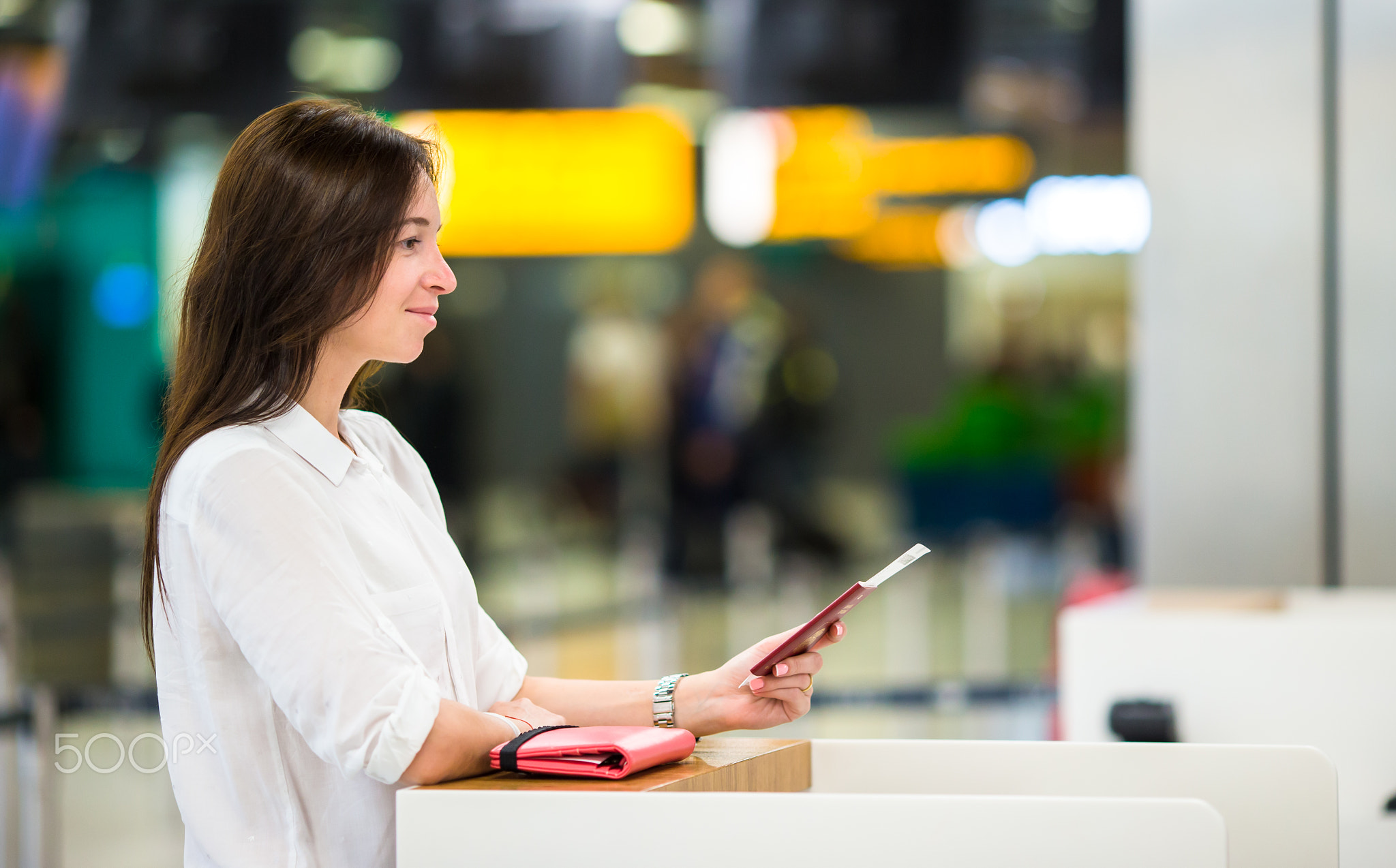 Woman with passports and boarding passes at the front desk at airport