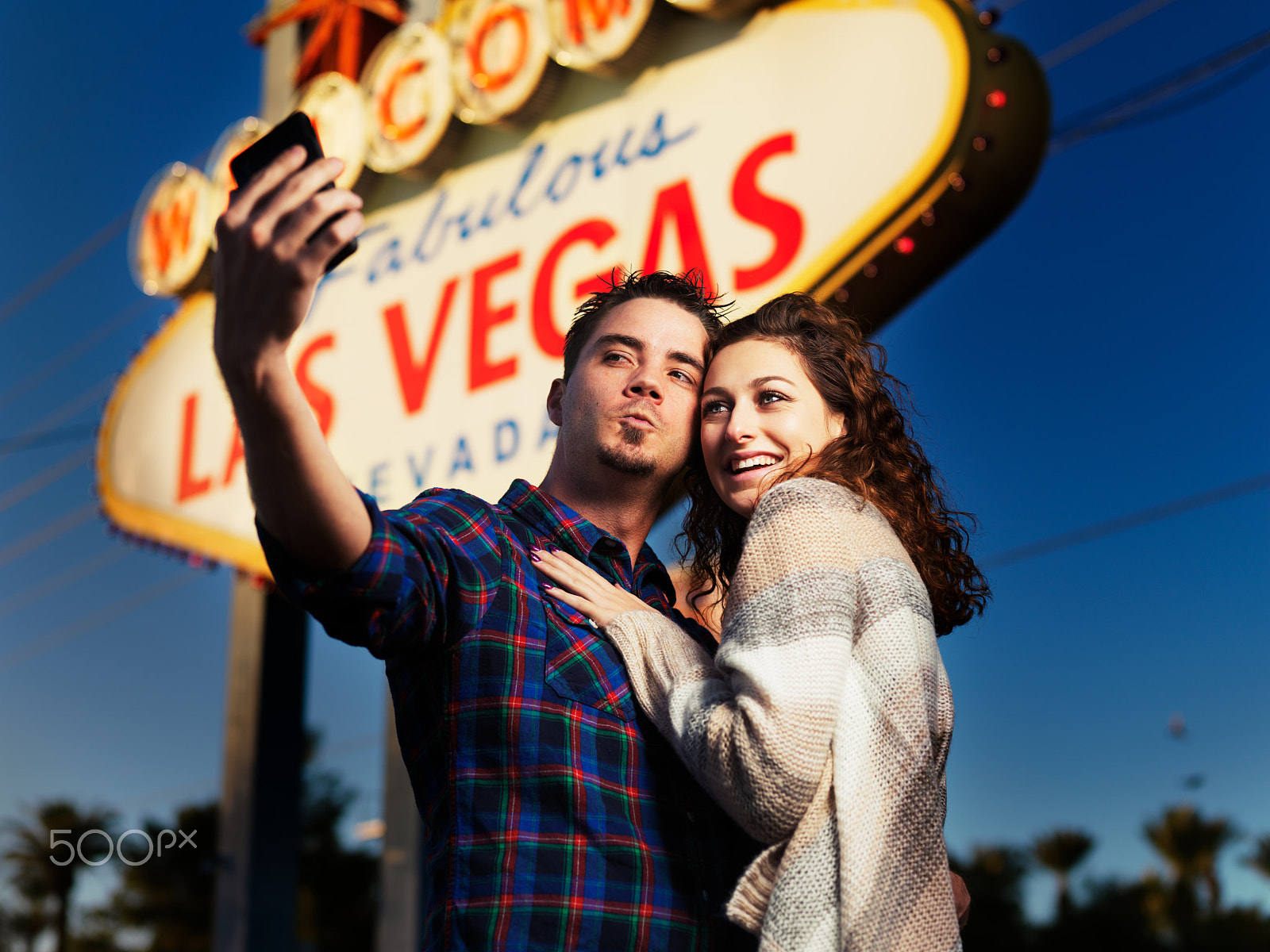 Hasselblad H3DII-39 sample photo. Couple taking selfies in front of lit up las vegas sign at night photography