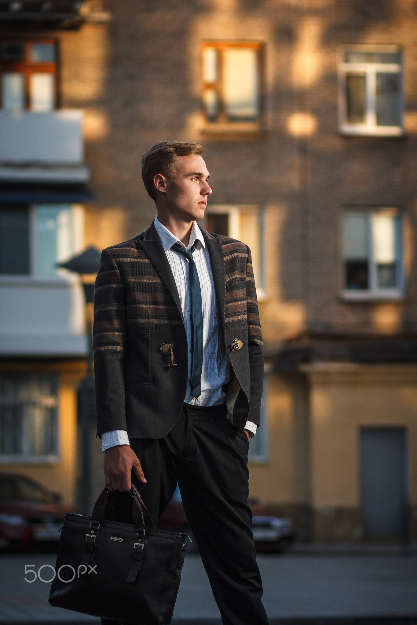 Young handsome successful stylish businessman standing