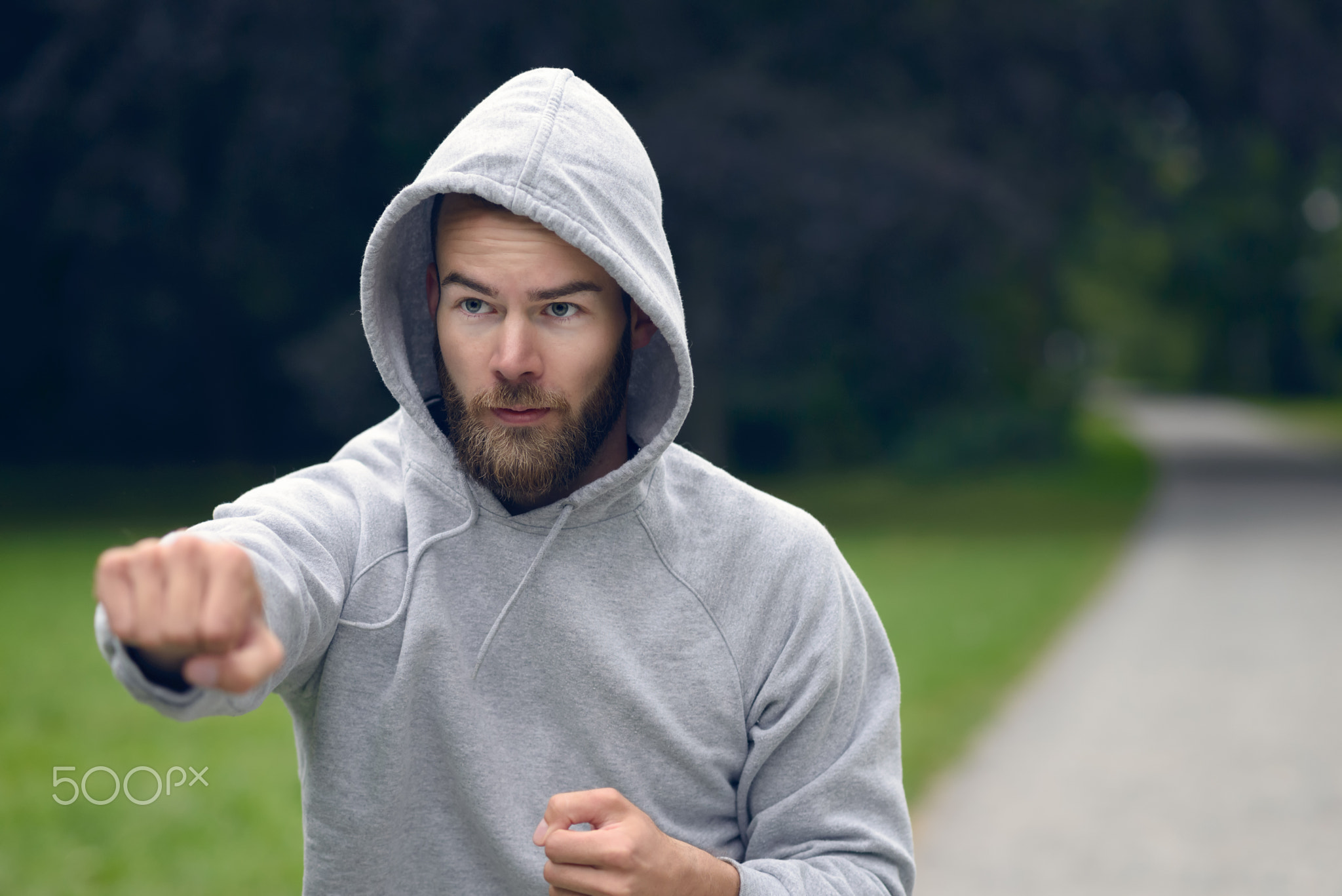 Young man working out in a park punching air
