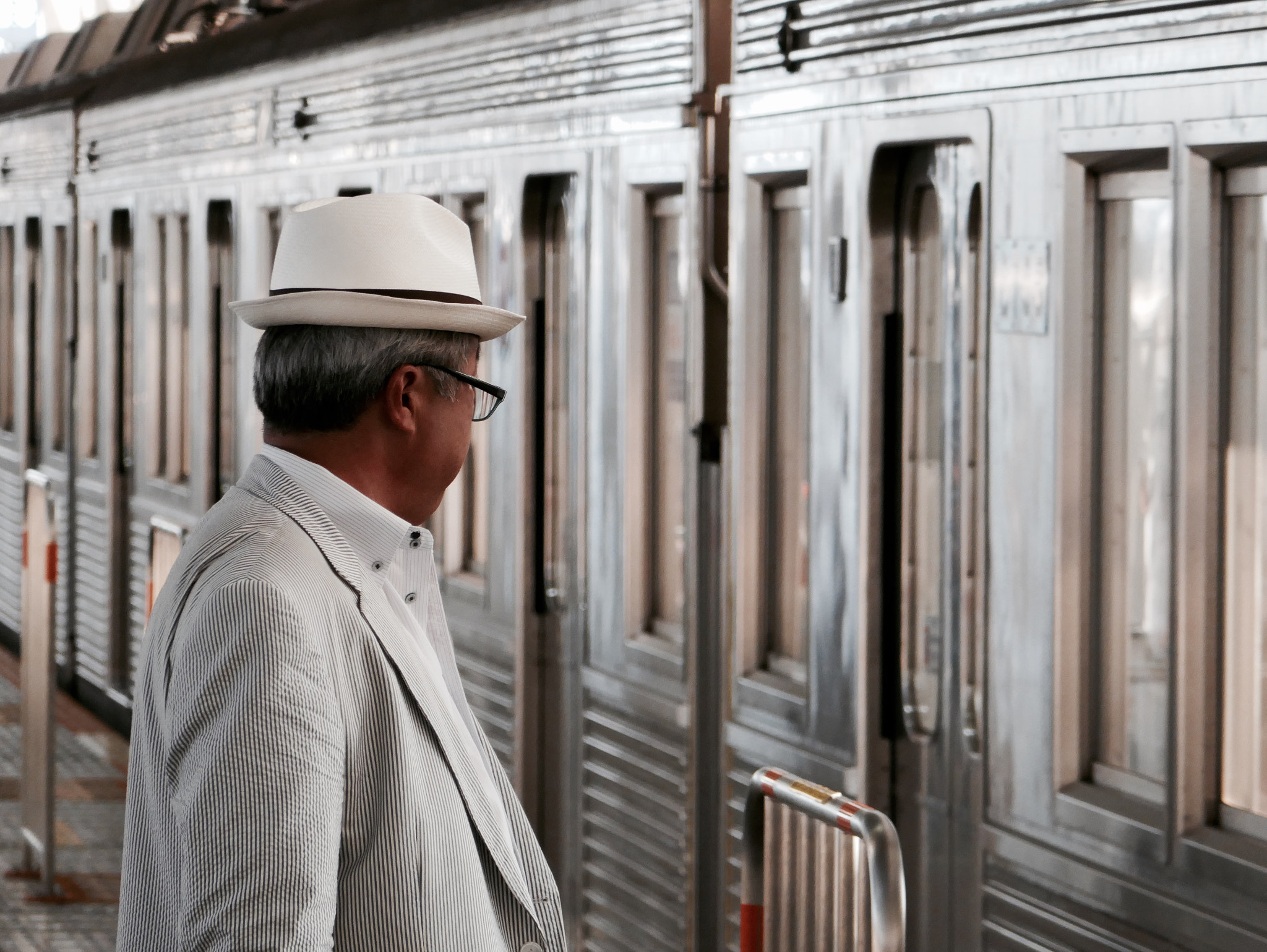 Panasonic DMC-TX1 sample photo. A man waiting for his train photography