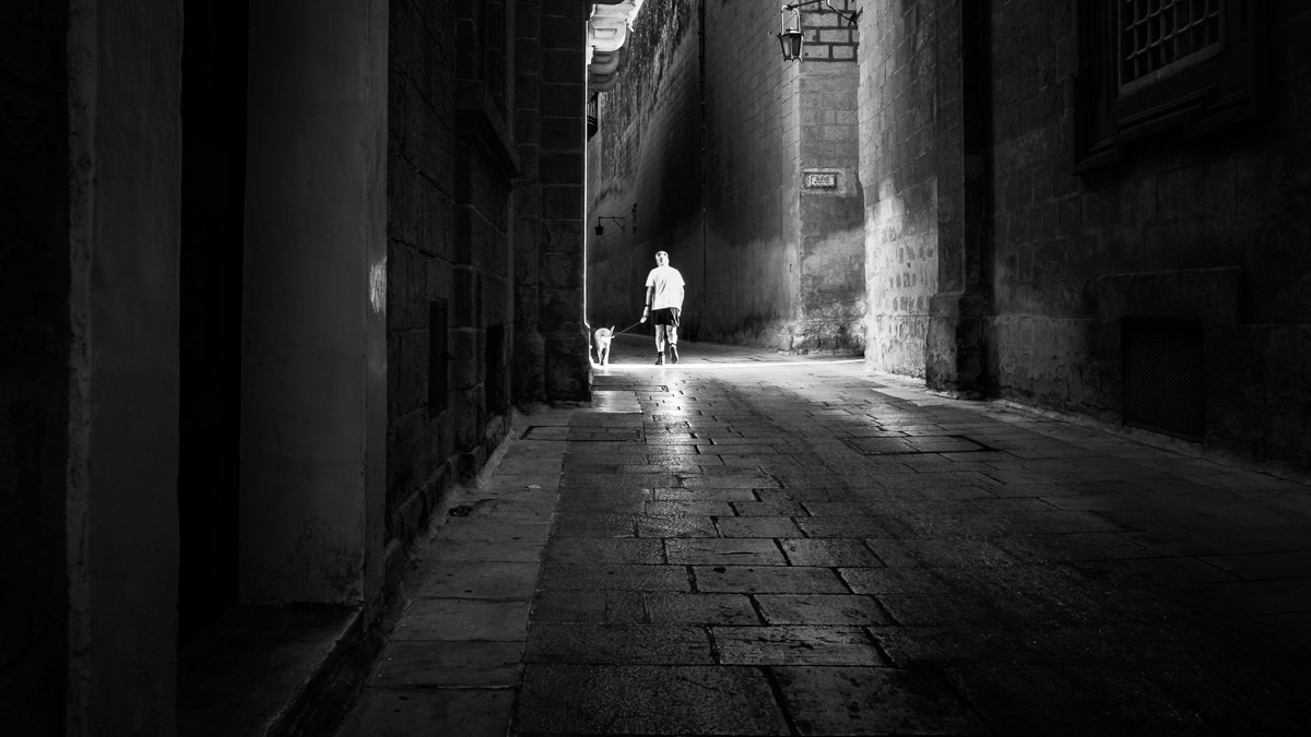 Fujifilm X-E2 + Fujifilm XF 18mm F2 R sample photo. Walking the dog - mdina, malta - black and white street photography photography