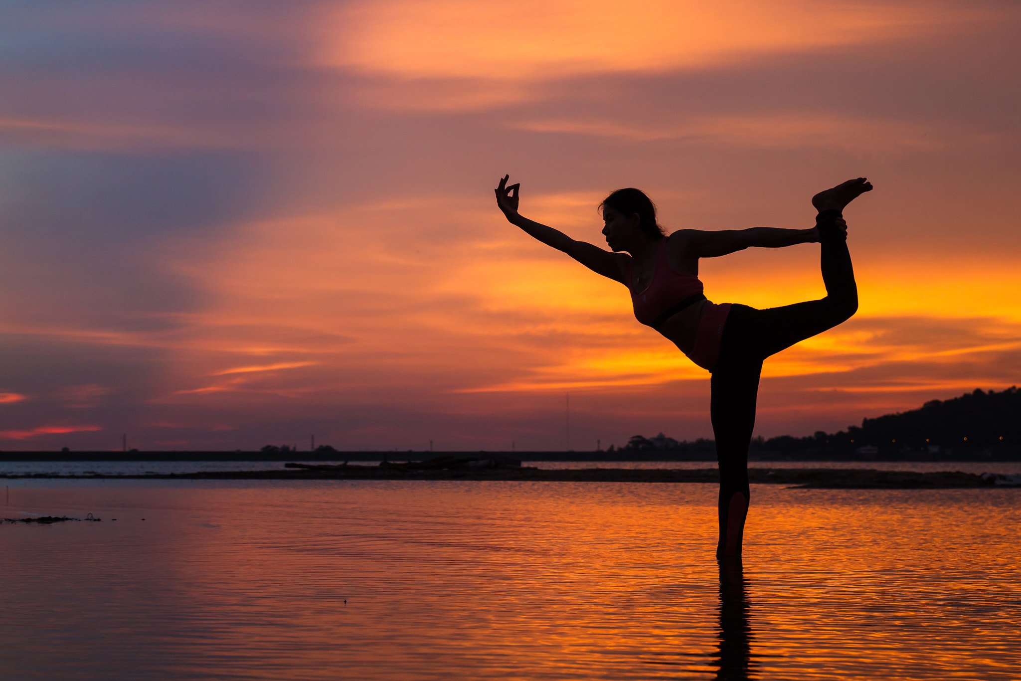 Canon EOS 500D (EOS Rebel T1i / EOS Kiss X3) sample photo. Silhouette of young woman practicing yoga on the lake at sunset photography