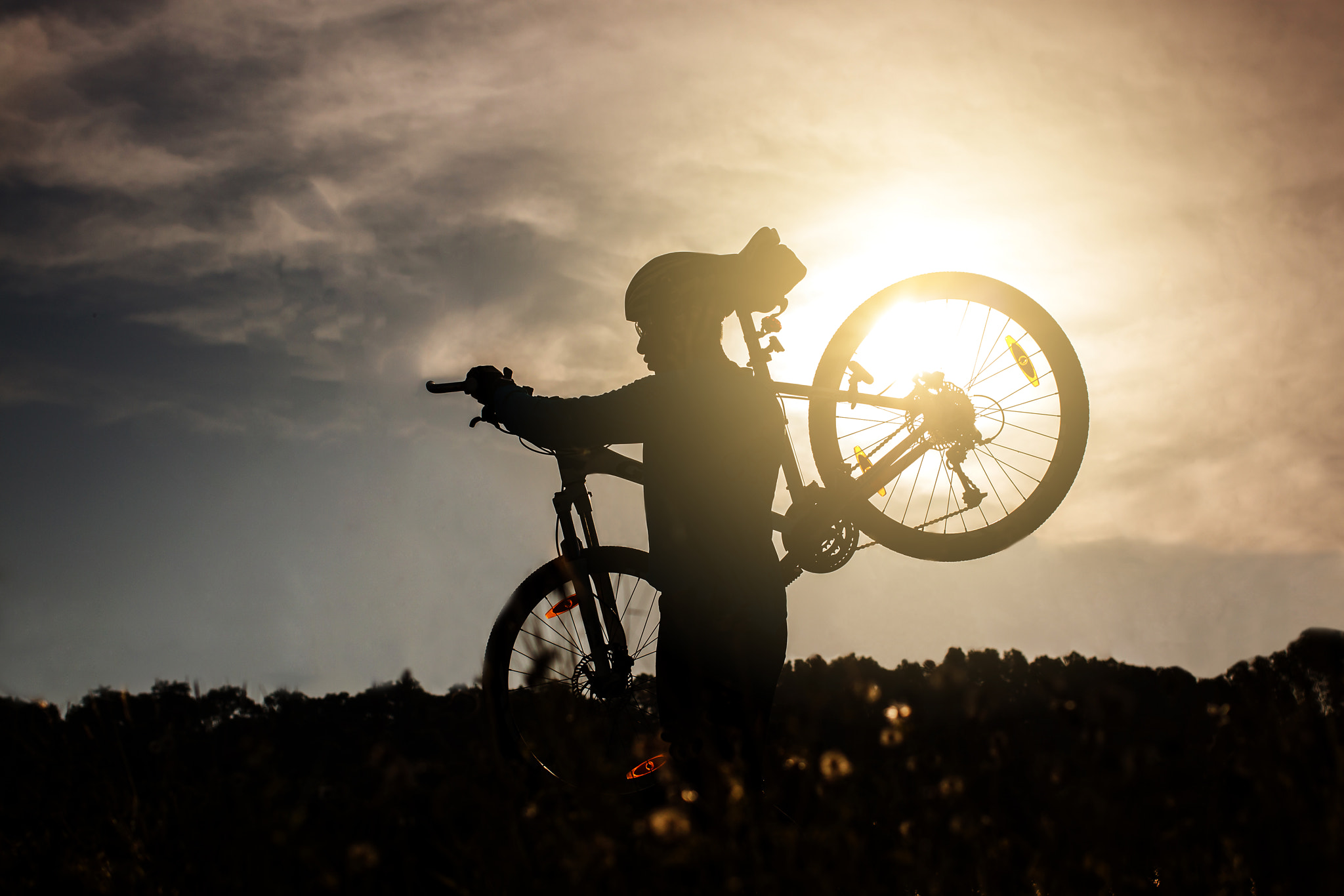 Canon EOS 500D (EOS Rebel T1i / EOS Kiss X3) + Canon EF 40mm F2.8 STM sample photo. Silhouette of man cyclist carrying his bike at sunrise. photography