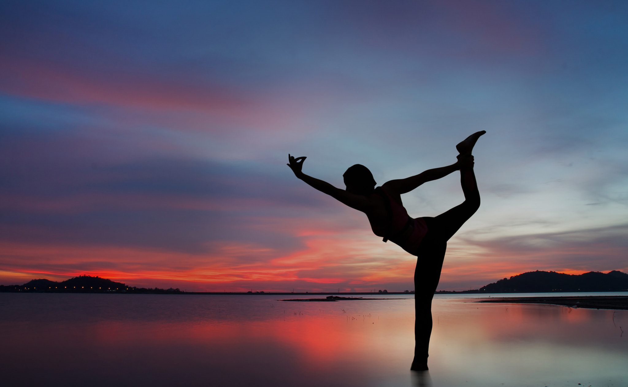 Canon EOS 500D (EOS Rebel T1i / EOS Kiss X3) sample photo. Silhouette of young woman practicing yoga on the lake at sunset photography