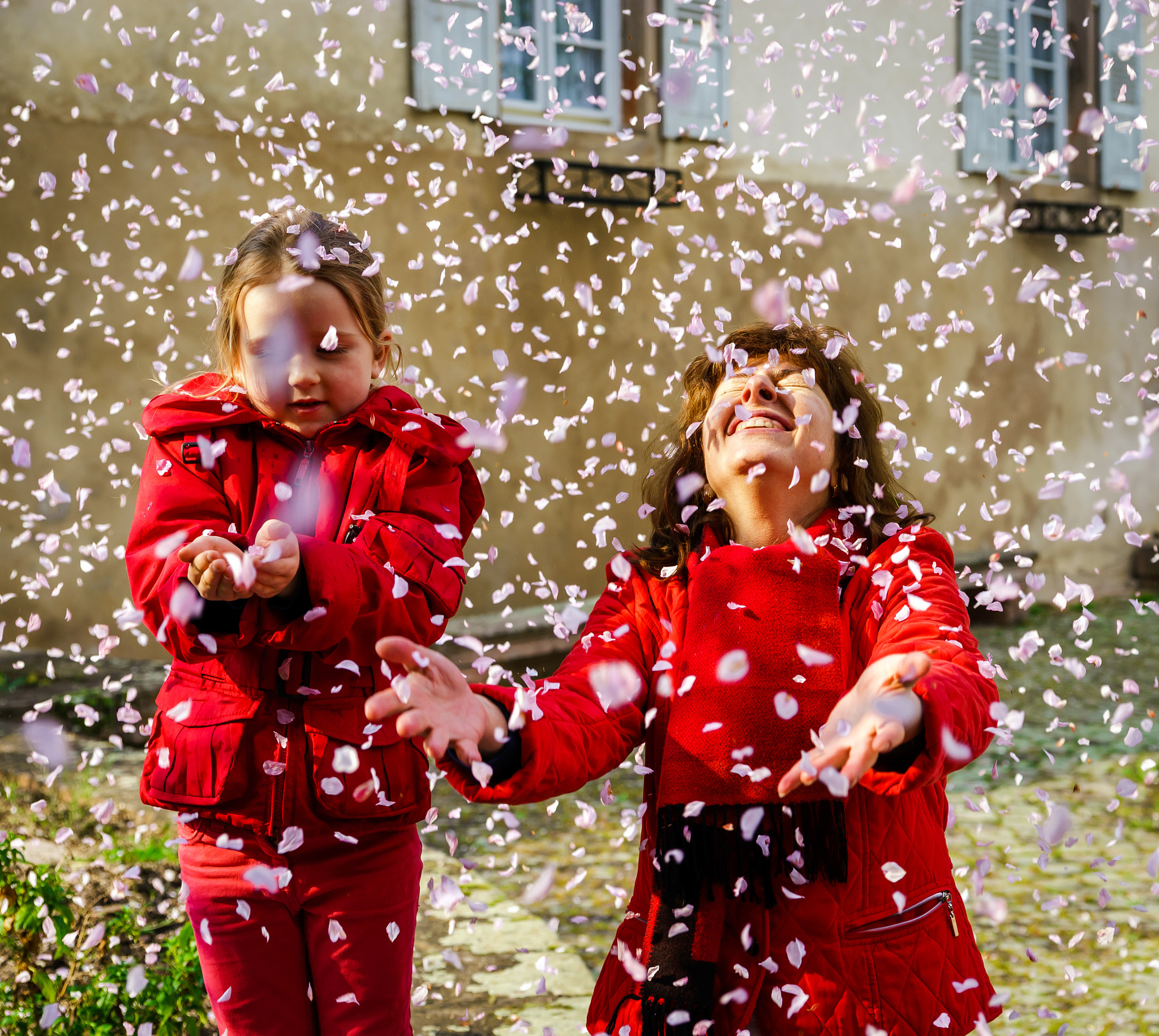 Sony Alpha a99 sample photo. Mother with little daughter playing with falling petals spring d photography