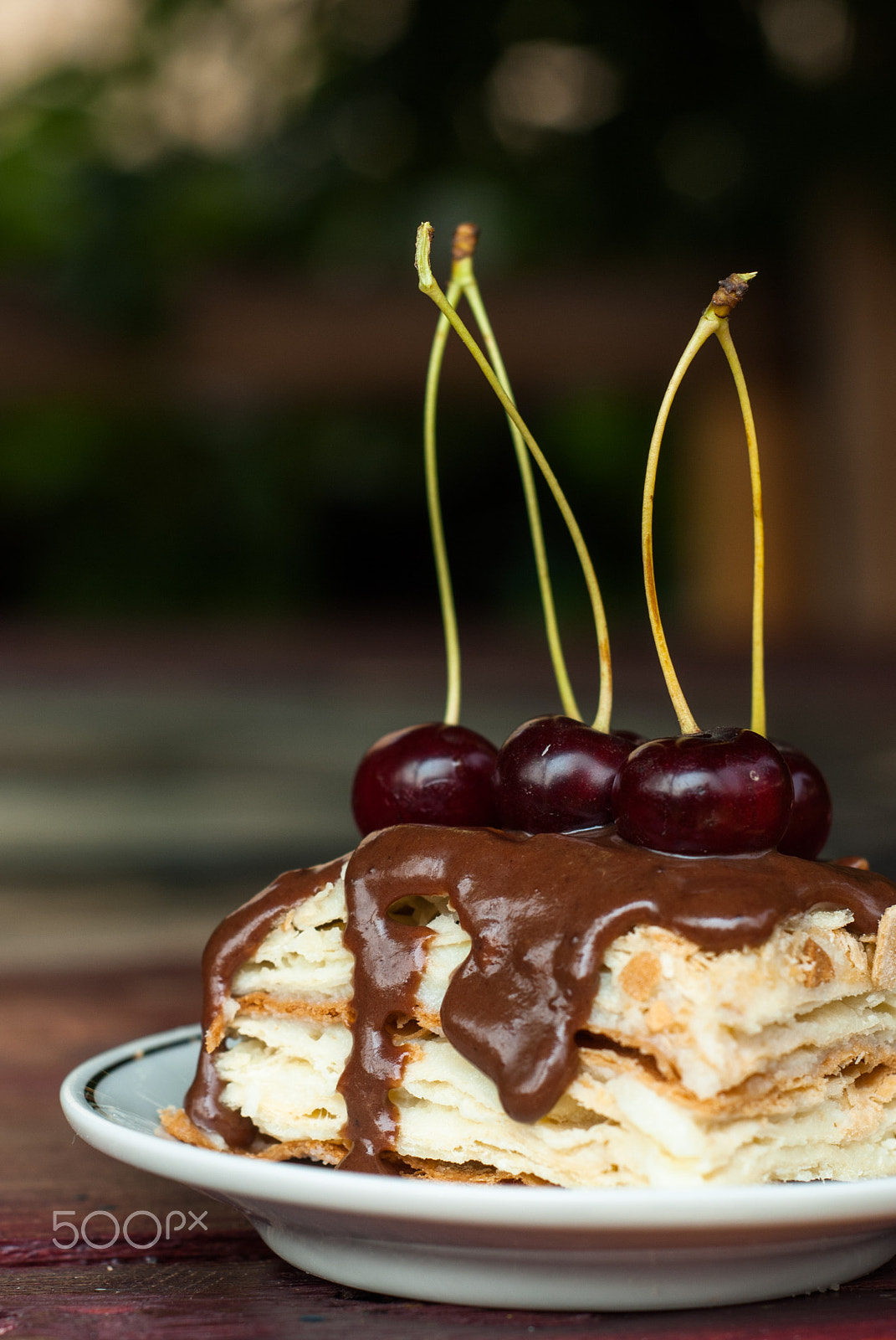Nikon D80 + AF Nikkor 50mm f/1.8 N sample photo. Piece of cake with chocolate icing and cherries, puff pastry napoleon  on a white plate, photography