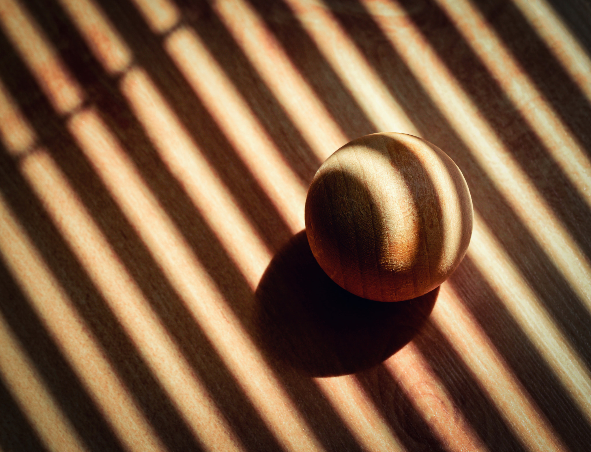 wooden ball covered with the shadow of sunblinds