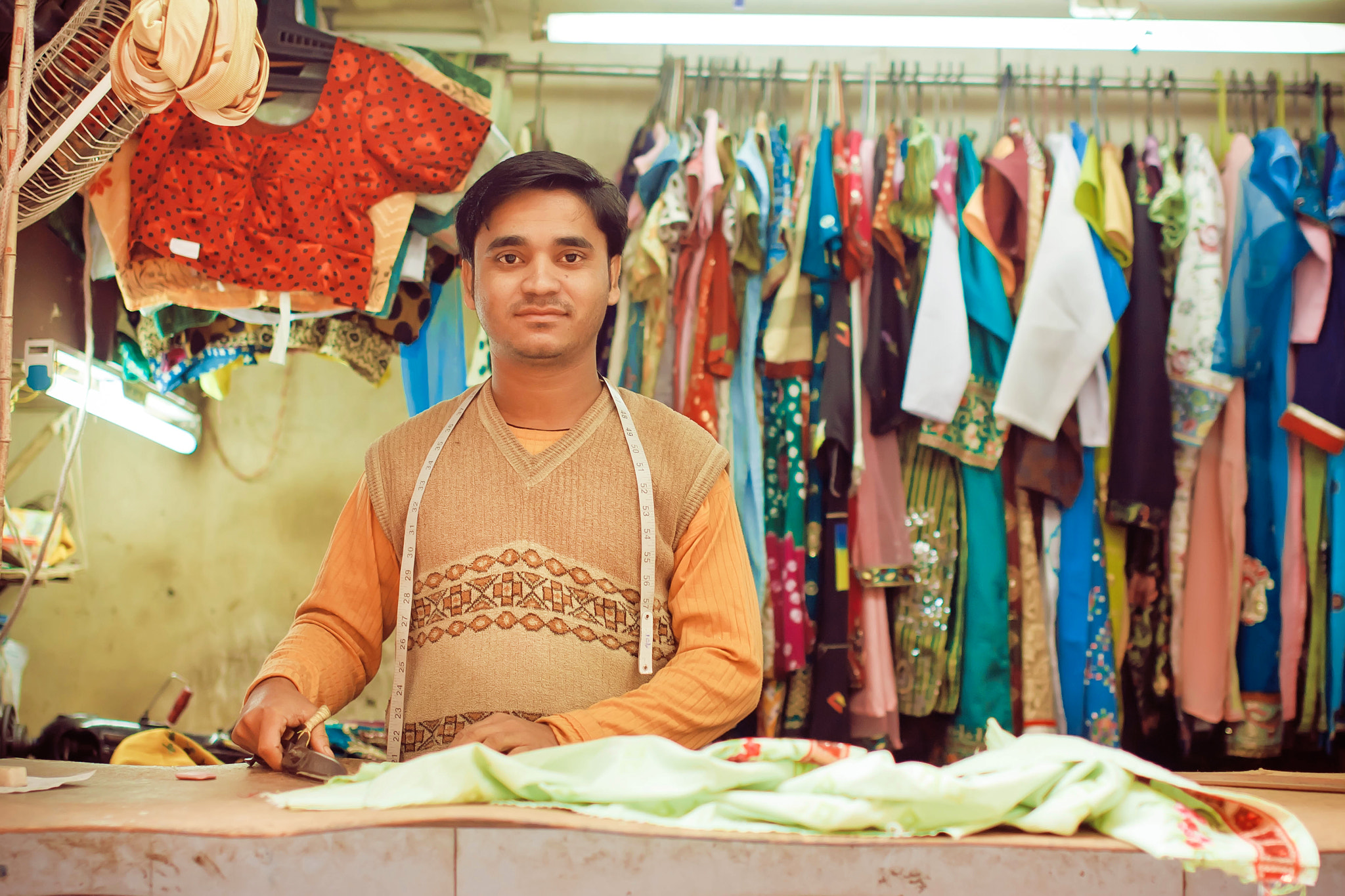 Young tailor sews clothes in a workshop