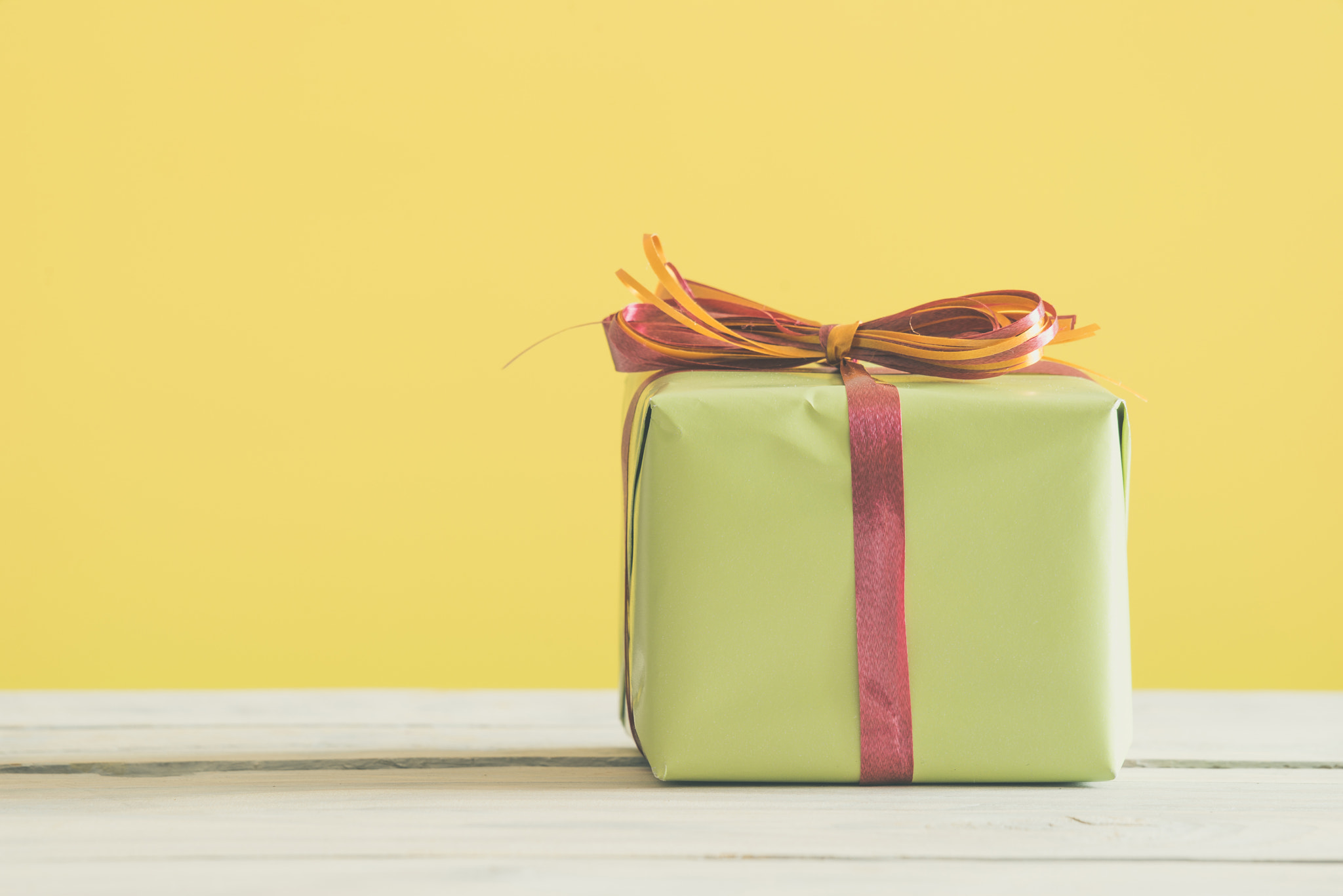 Sony a7R + Sony 70-400mm F4-5.6 G SSM II sample photo. Green gift with a red and orange ribbon photography