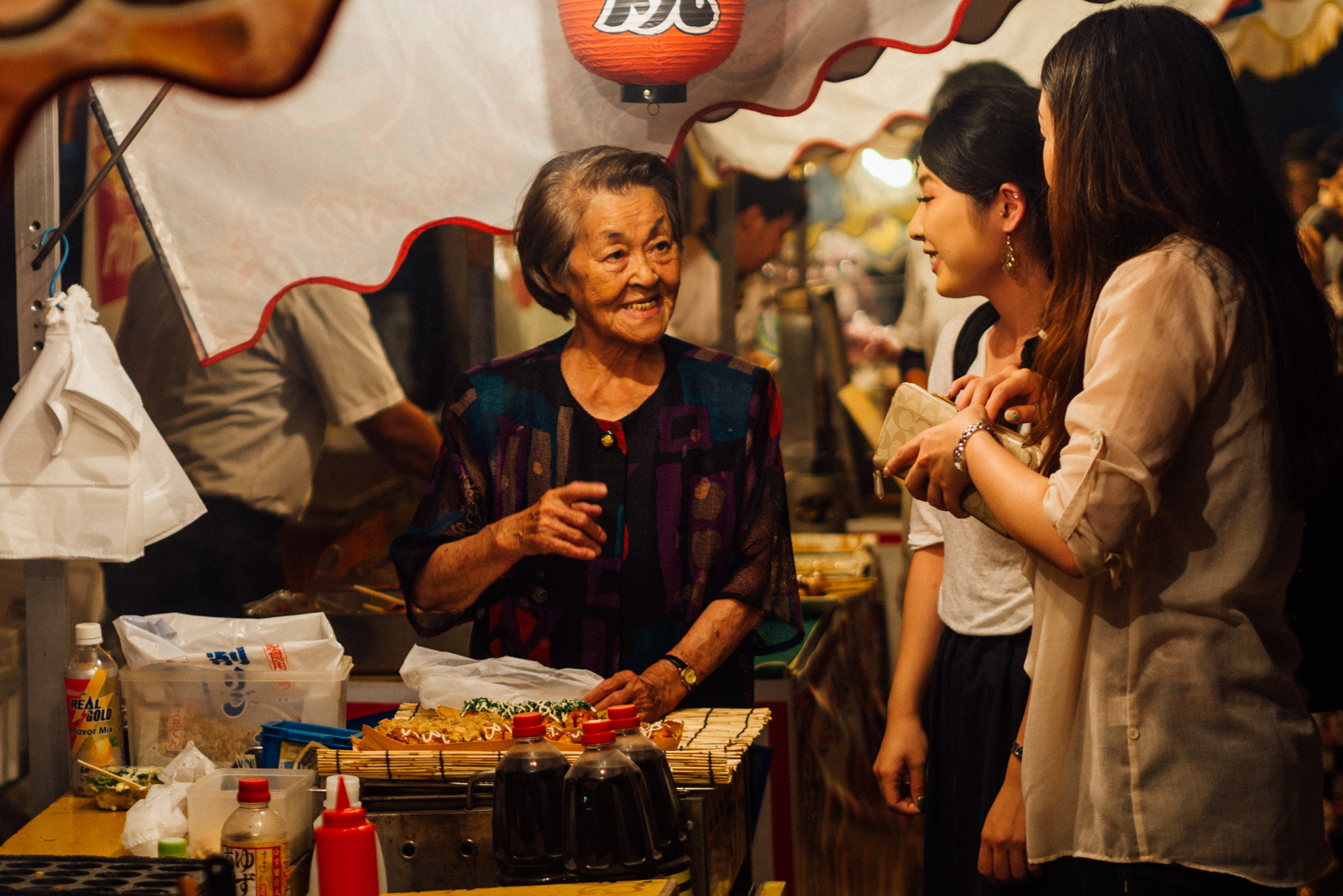 Panasonic Lumix DMC-GX7 + Olympus M.Zuiko Digital 45mm F1.8 sample photo. Lady at the food stall photography