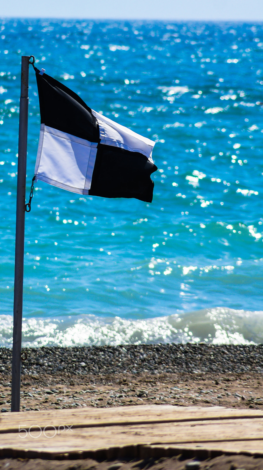 Sony SLT-A55 (SLT-A55V) + Sony DT 55-200mm F4-5.6 SAM sample photo. A black and white checkered flag on the beach photography