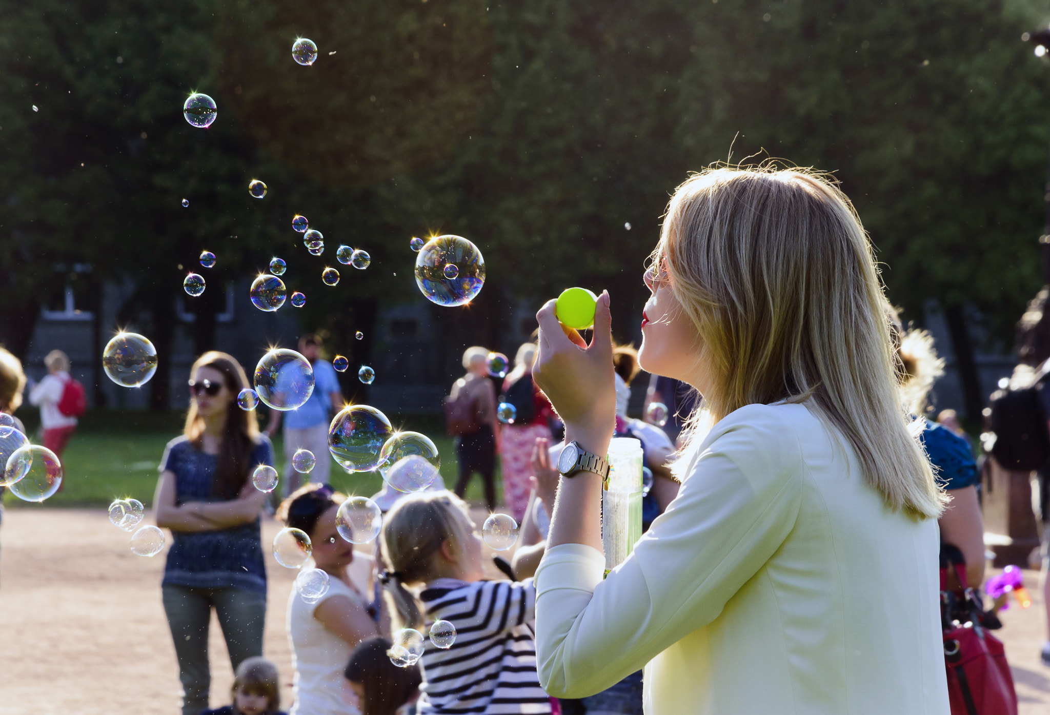 Nikon D5500 + Nikon AF-S DX Nikkor 18-135mm F3.5-5.6G ED-IF sample photo. Beautiful woman blowing soap bubbles in the park photography