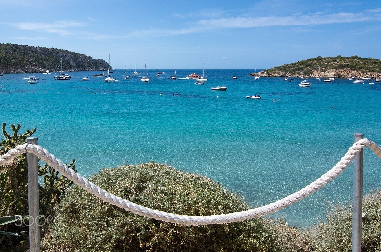 Nikon D7100 + Nikon AF Nikkor 20mm F2.8D sample photo. Turquoise ocean bay with boats and rope fence photography