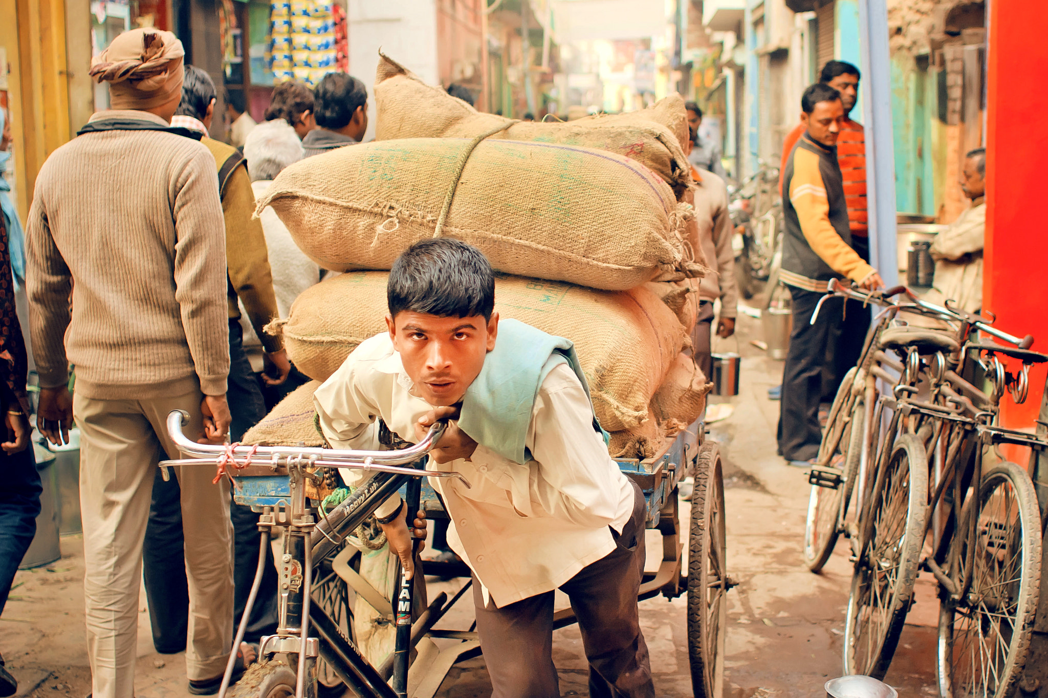 Canon EOS 40D + Canon EF 28mm F1.8 USM sample photo. Hard working young man carries heavy bags of cargo photography