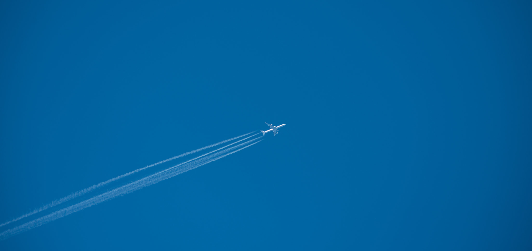 Nikon AF-S Nikkor 300mm F2.8G ED VR II sample photo. Shot of a jet plane high in the blue sky photography