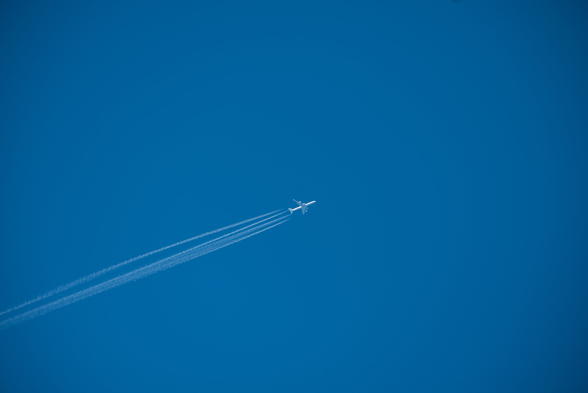 Nikon AF-S Nikkor 300mm F2.8G ED VR II sample photo. Shot of a jet plane high in the blue sky photography