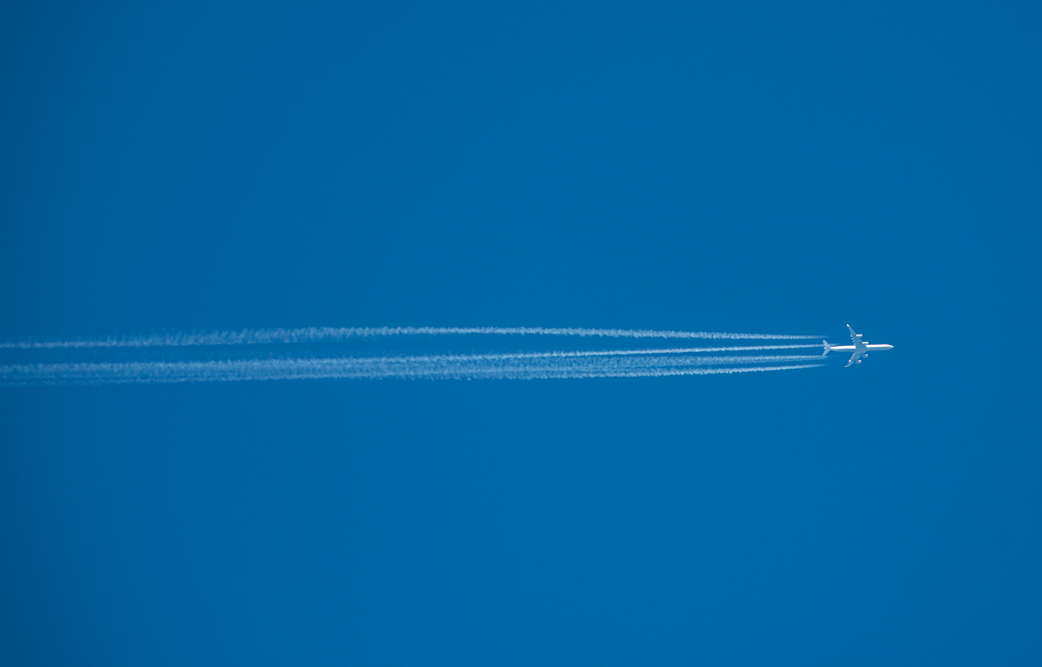 Nikon AF-S Nikkor 300mm F2.8G ED VR II sample photo. Shot of a jet plane high in the blue sky photography