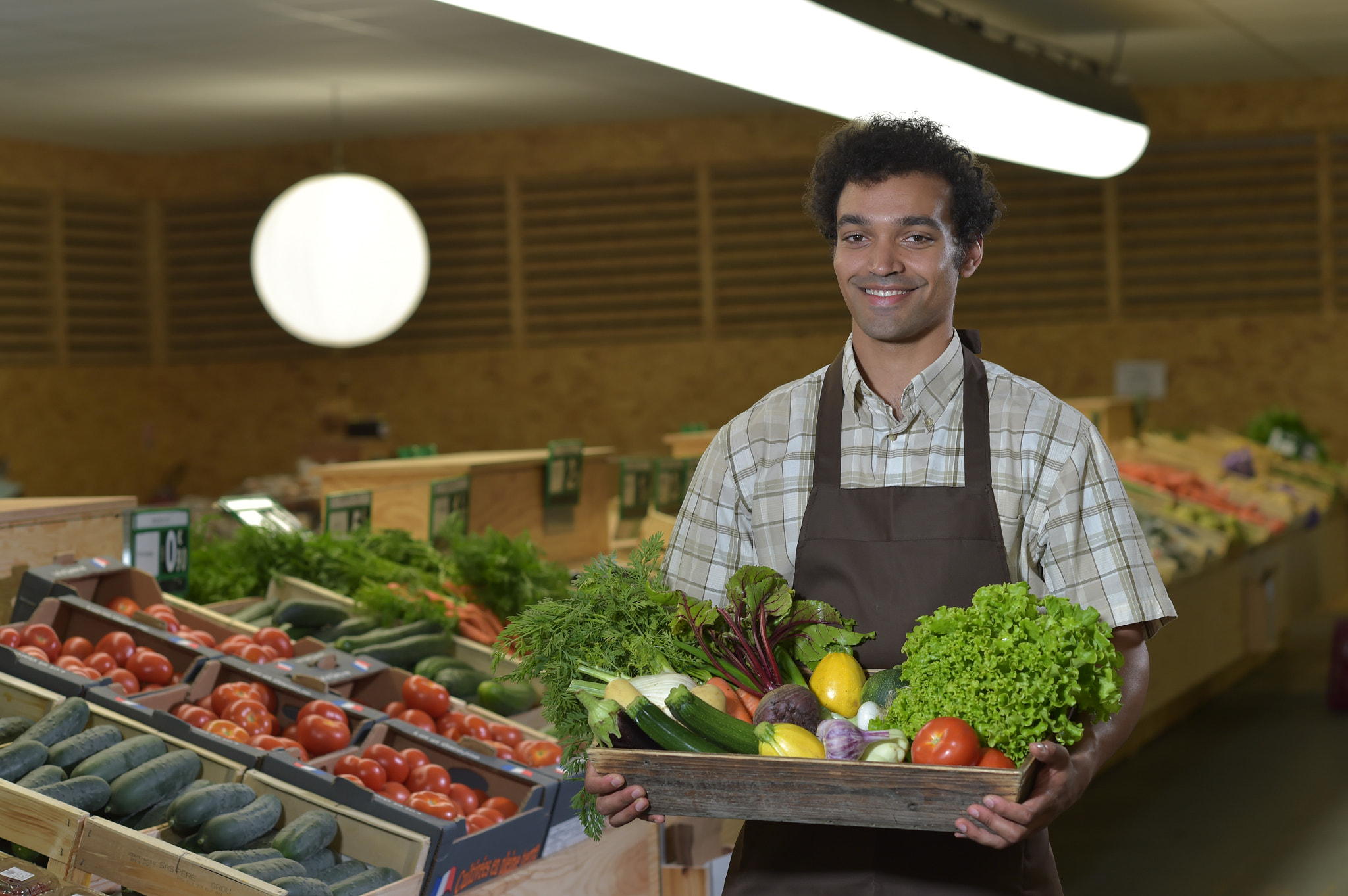 Nikon D4S + Nikon AF-S Nikkor 85mm F1.4G sample photo. Grocery clerk working in produce aisle of supermarket store photography