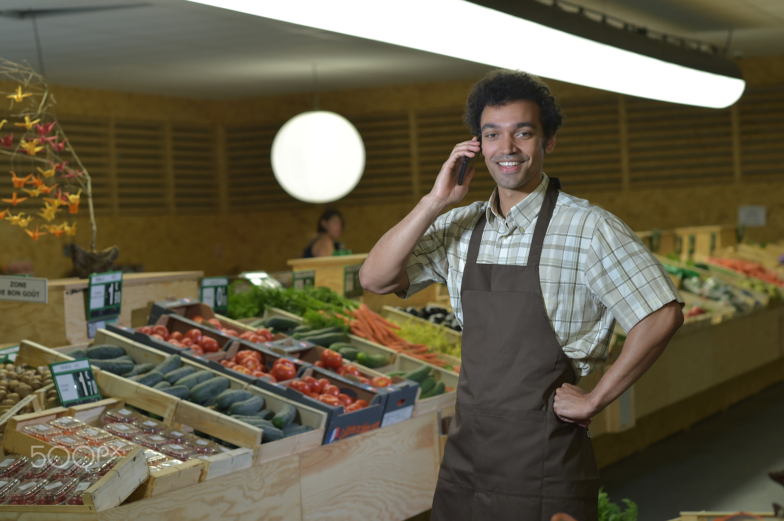Nikon D4S + Nikon AF-S Nikkor 85mm F1.4G sample photo. Grocery clerk phoning in produce aisle of supermarket store photography
