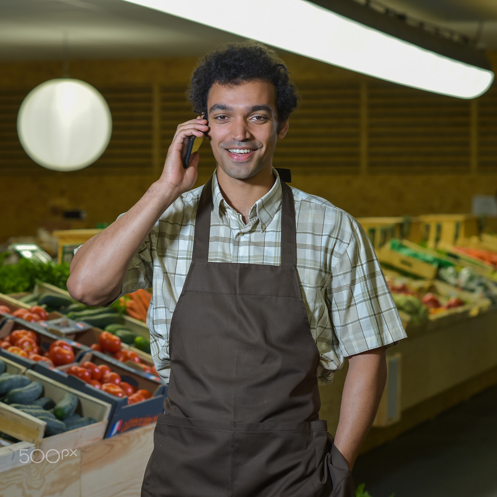 Nikon D4S + Nikon AF-S Nikkor 85mm F1.4G sample photo. Grocery clerk phoning in produce aisle of supermarket store photography