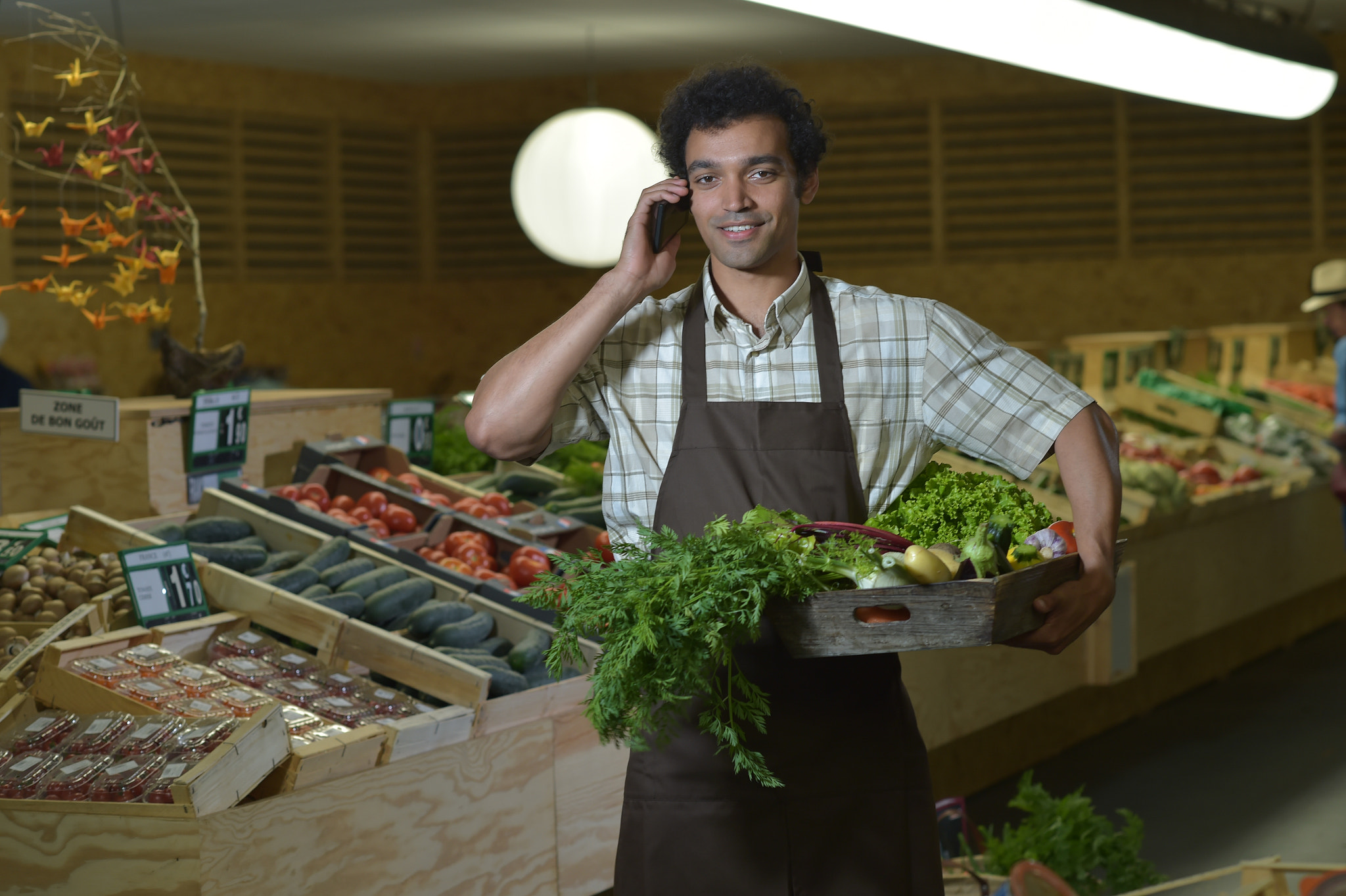 Nikon D4S + Nikon AF-S Nikkor 85mm F1.4G sample photo. Grocery clerk phoning in produce aisle of supermarket store photography