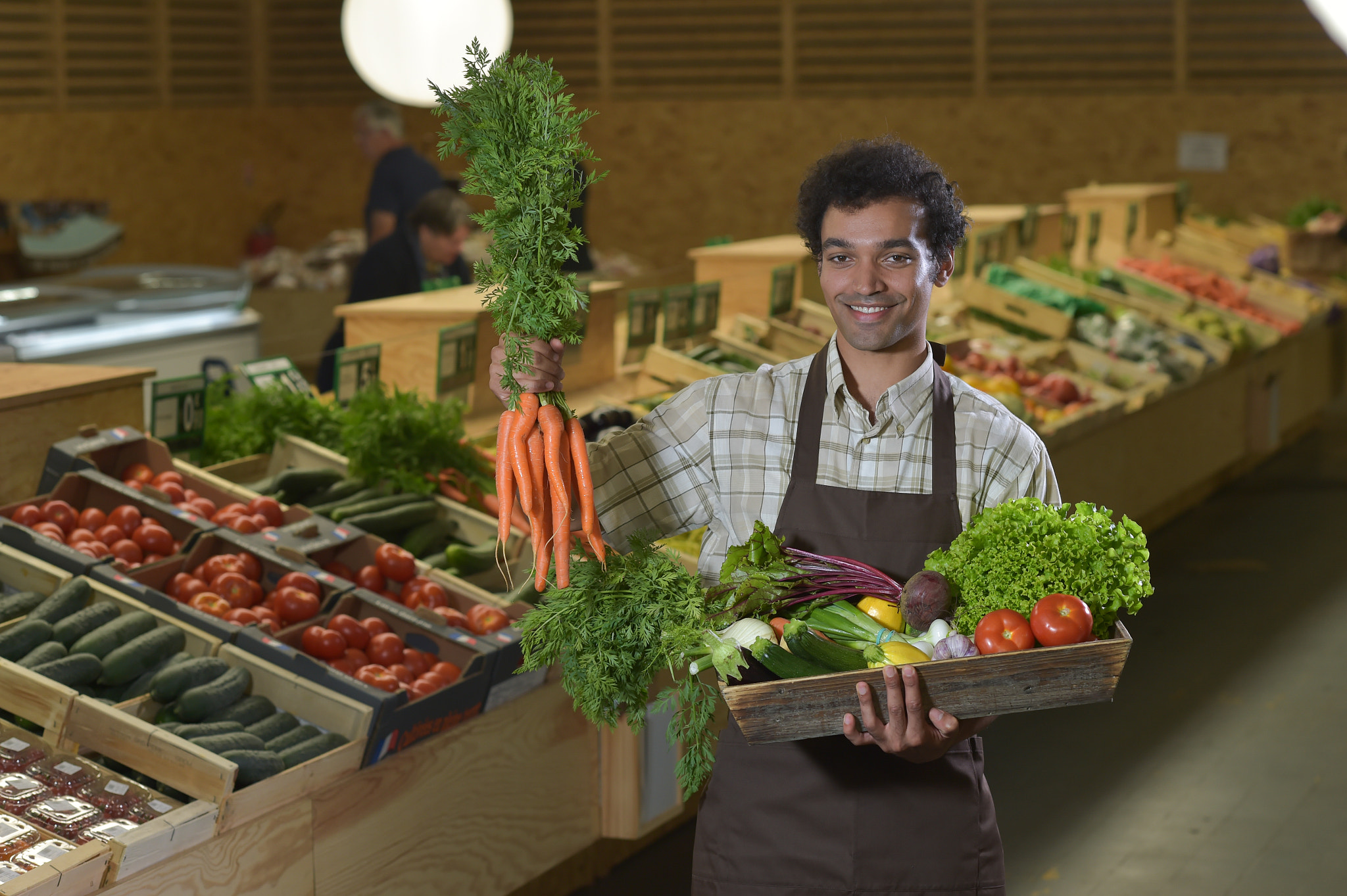 Nikon D4S + Nikon AF-S Nikkor 85mm F1.4G sample photo. Grocery clerk working in produce aisle of supermarket store photography