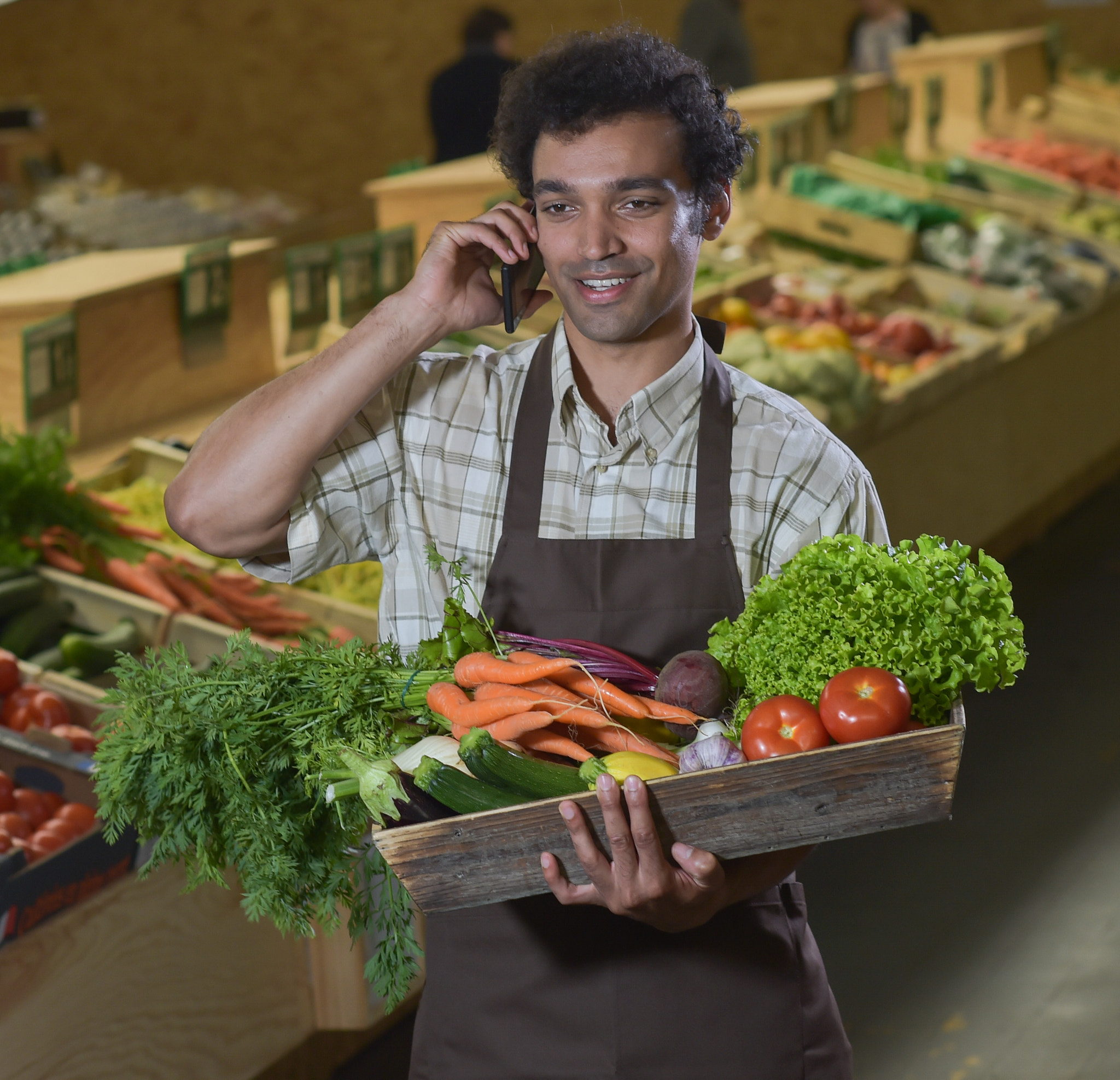 Nikon D4S + Nikon AF-S Nikkor 85mm F1.4G sample photo. Grocery clerk phoning in produce aisle of supermarket store photography