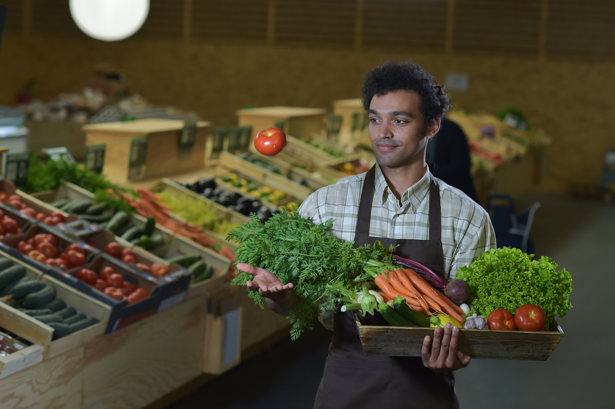 Nikon D4S + Nikon AF-S Nikkor 85mm F1.4G sample photo. Grocery clerk working in produce aisle of supermarket store photography